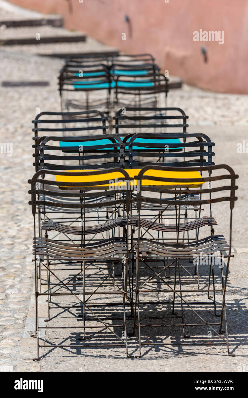 Sillas y mesas de metal moderno y destartalado y elegante al lado de una cafetería en la ciudad griega de kerkyra, Corfú, Grecia. Foto de stock