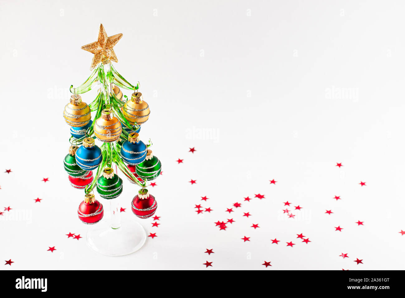 Concepto de Navidad. Rojo, verde, azul y oro bolas decorativas decorar el árbol de navidad con una estrella en la parte superior. Estrellas rojas alrededor del árbol de Navidad. Foto de stock