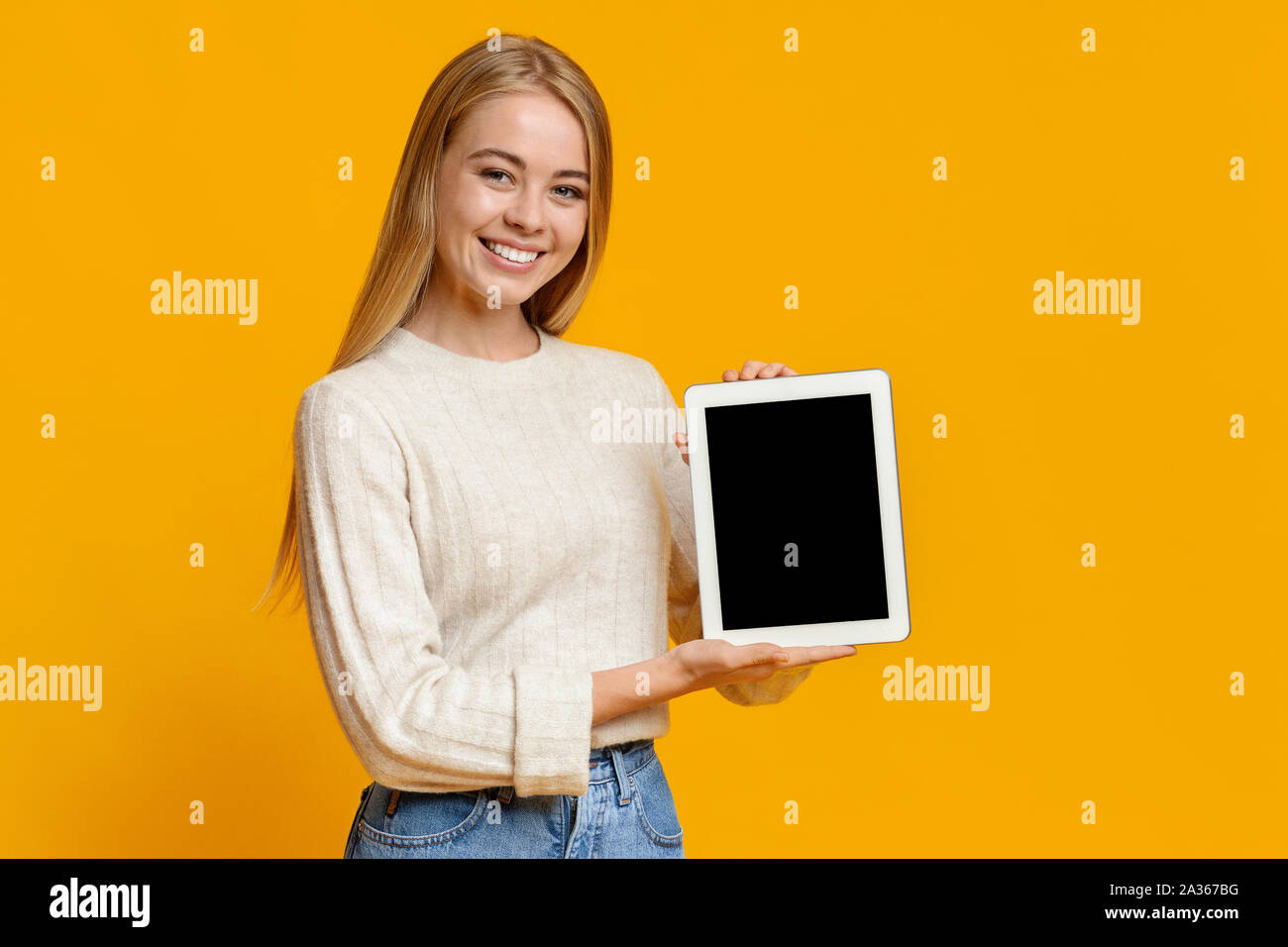 Hermosa jovencita holding tableta digital con pantalla en blanco Foto de stock