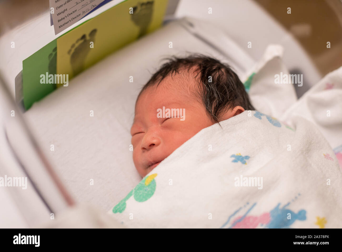 Bebé recién nacido envuelto en toalla celebrada por enfermera, cierre en  vertical Fotografía de stock - Alamy