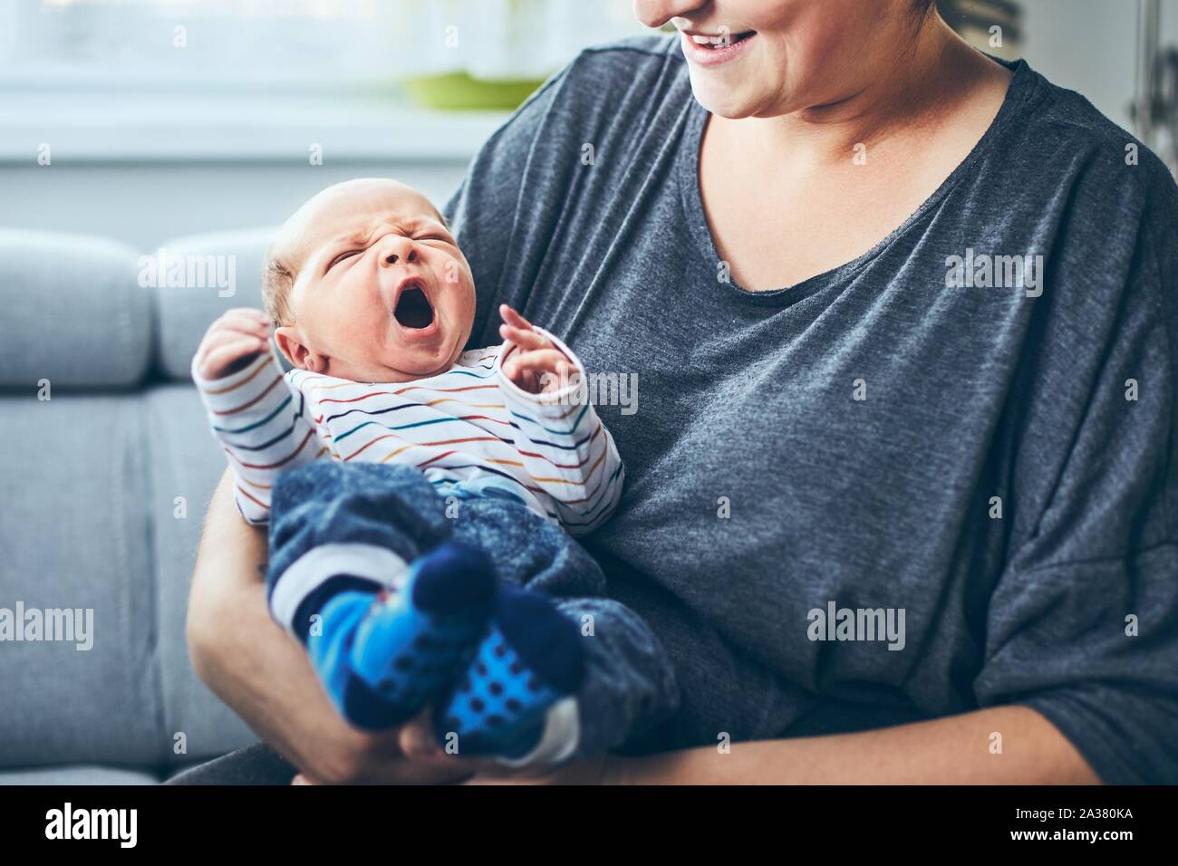 La madre con el recién nacido. Una mujer sostiene a su hijo de 4 días en casa. Foto de stock