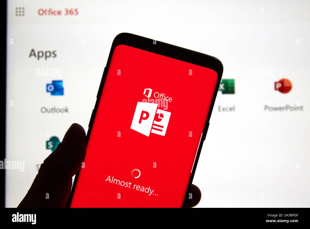 MONTREAL, Canadá - 24 de abril de 2019: un teléfono celular con el logotipo  de Microsoft PowerPoint y app a través de la pantalla de la laptop.  Microsoft Office es una familia