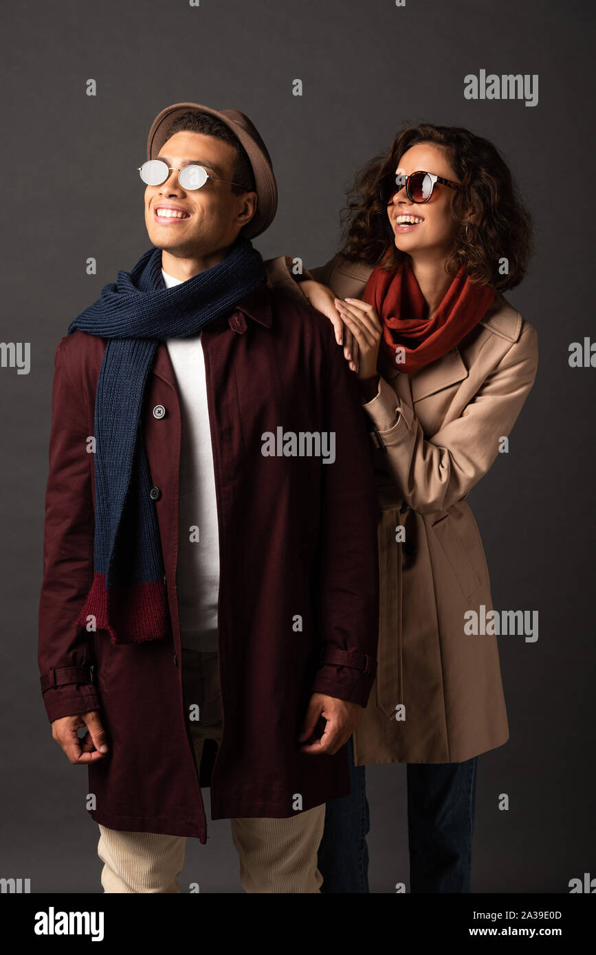 Elegante sonriente pareja interracial en otoño outfit apartar la mirada  sobre fondo negro Fotografía de stock - Alamy