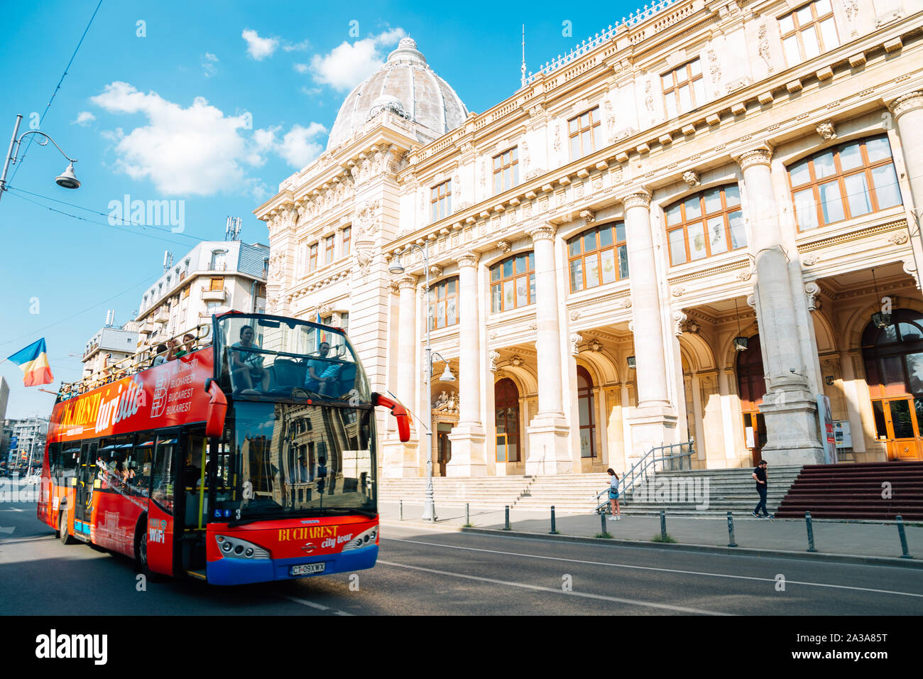 Bucarest, Rumania - Julio 27, 2019 : City tour bus y el Museo Nacional de Historia de Rumania en Victoria Street Foto de stock