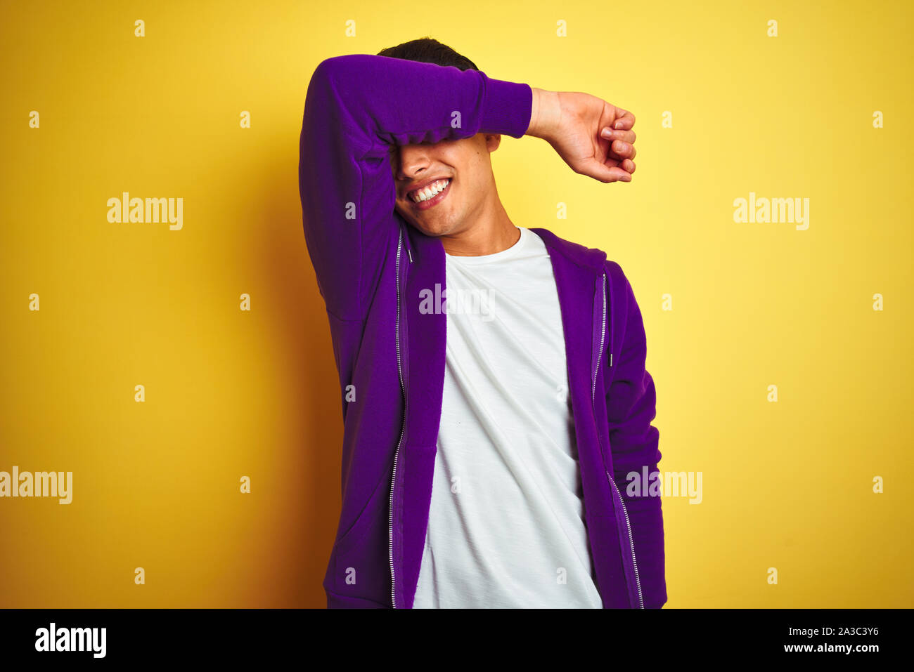 Joven brasileño hombre vestido con sudadera morada permanente aislado sobre  fondo amarillo, cubriéndose los ojos con el brazo sonriendo alegre y  divertido. Concepto ciega Fotografía de stock - Alamy
