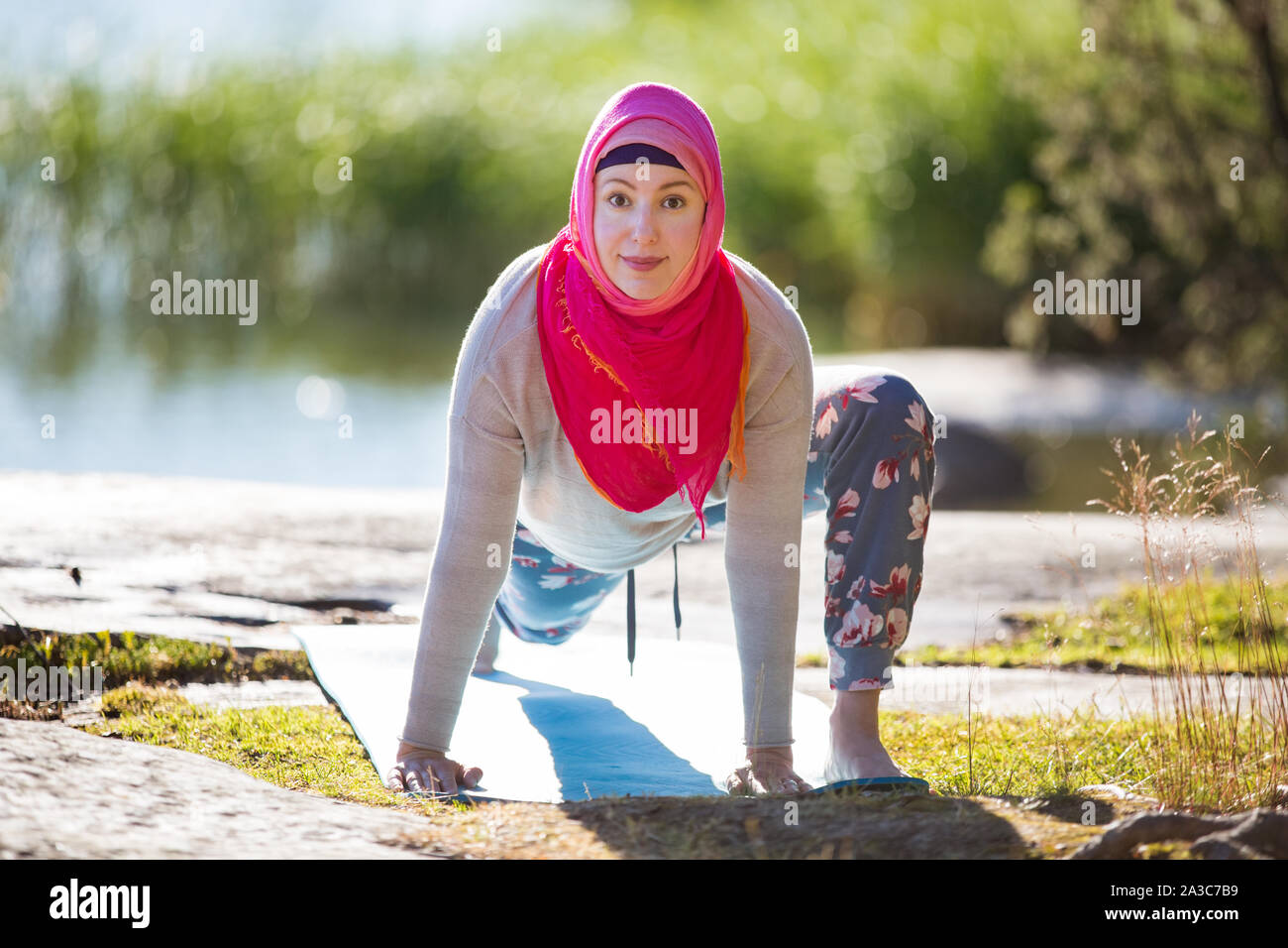 Mujer atractiva en el hijab formación en el parque, meditando. Haciendo ejercicios de yoga en el aire fresco y disfrutar de la madrugada. Estilo de vida saludable Foto de stock