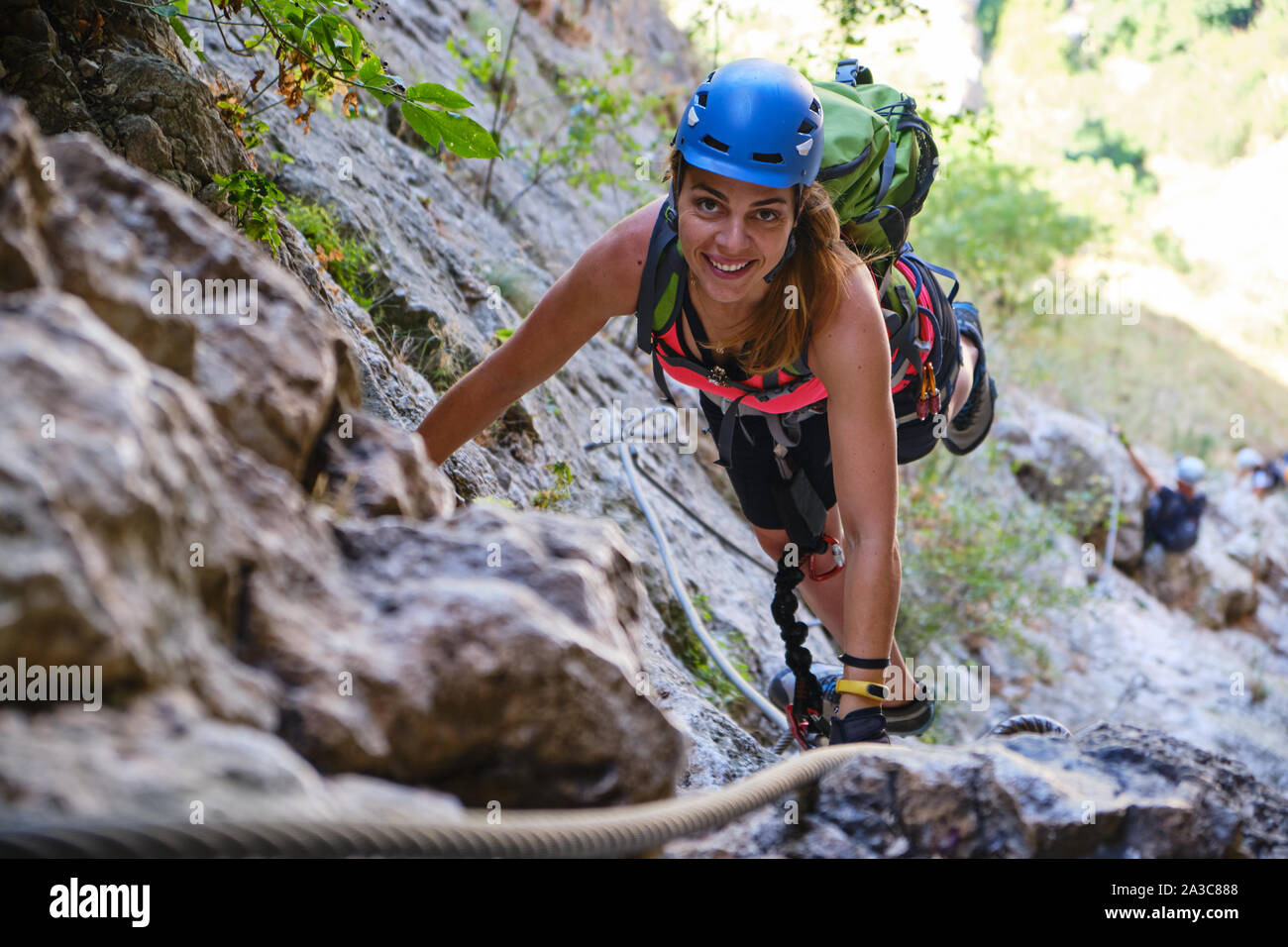 Mujer feliz escalando una vía ferrata ruta en Turda Gorge (Cheile Turzii), Rumania. Foto de stock
