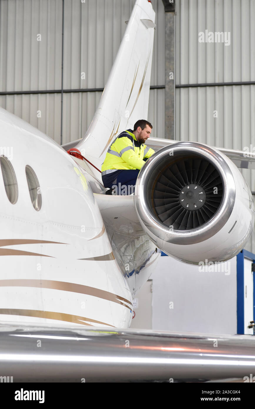 Los trabajadores del aeropuerto un avión para comprobar la seguridad de un hangar Foto de stock