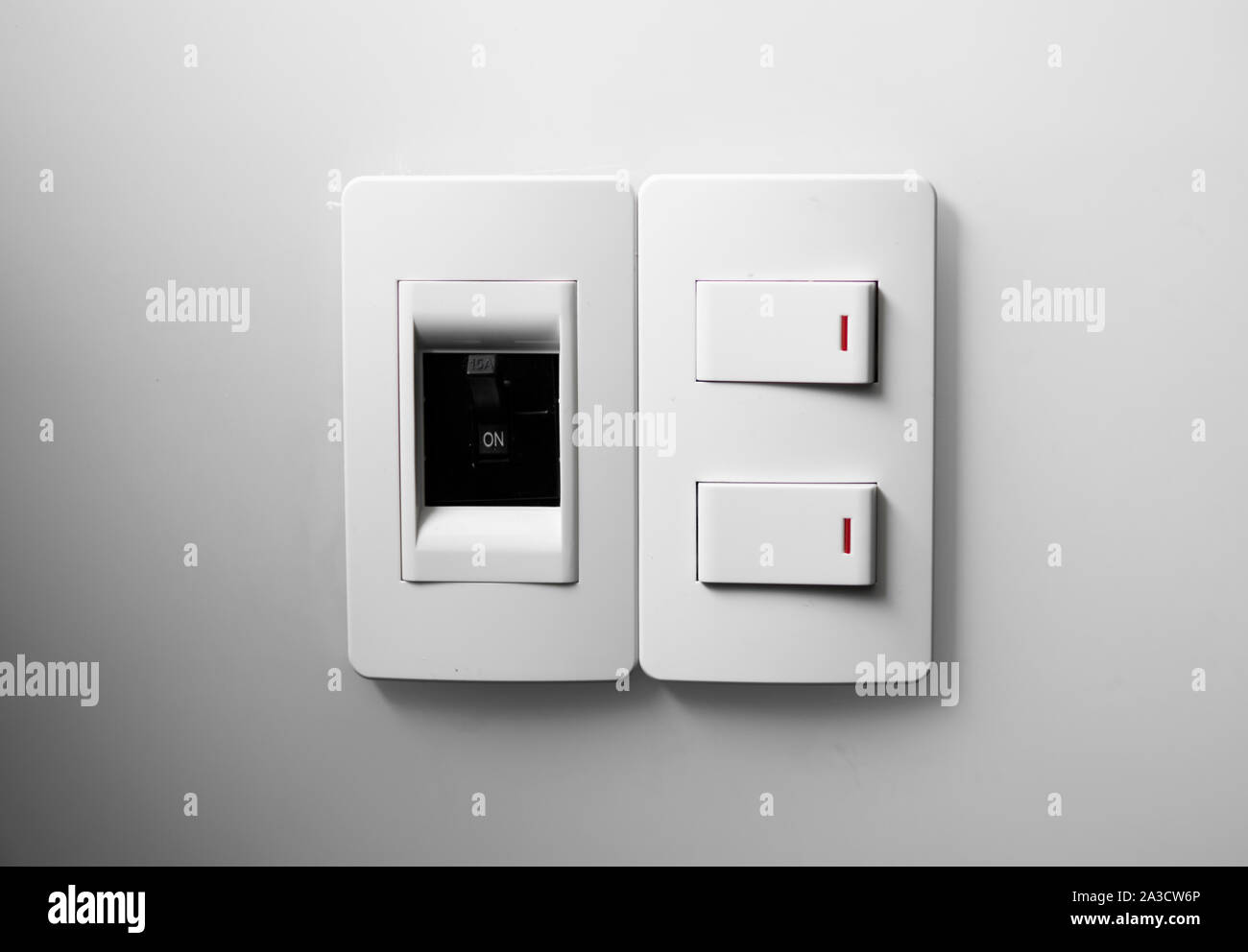 Interruptor blanco sobre una pared blanca con dos interruptores y un  interruptor común Fotografía de stock - Alamy