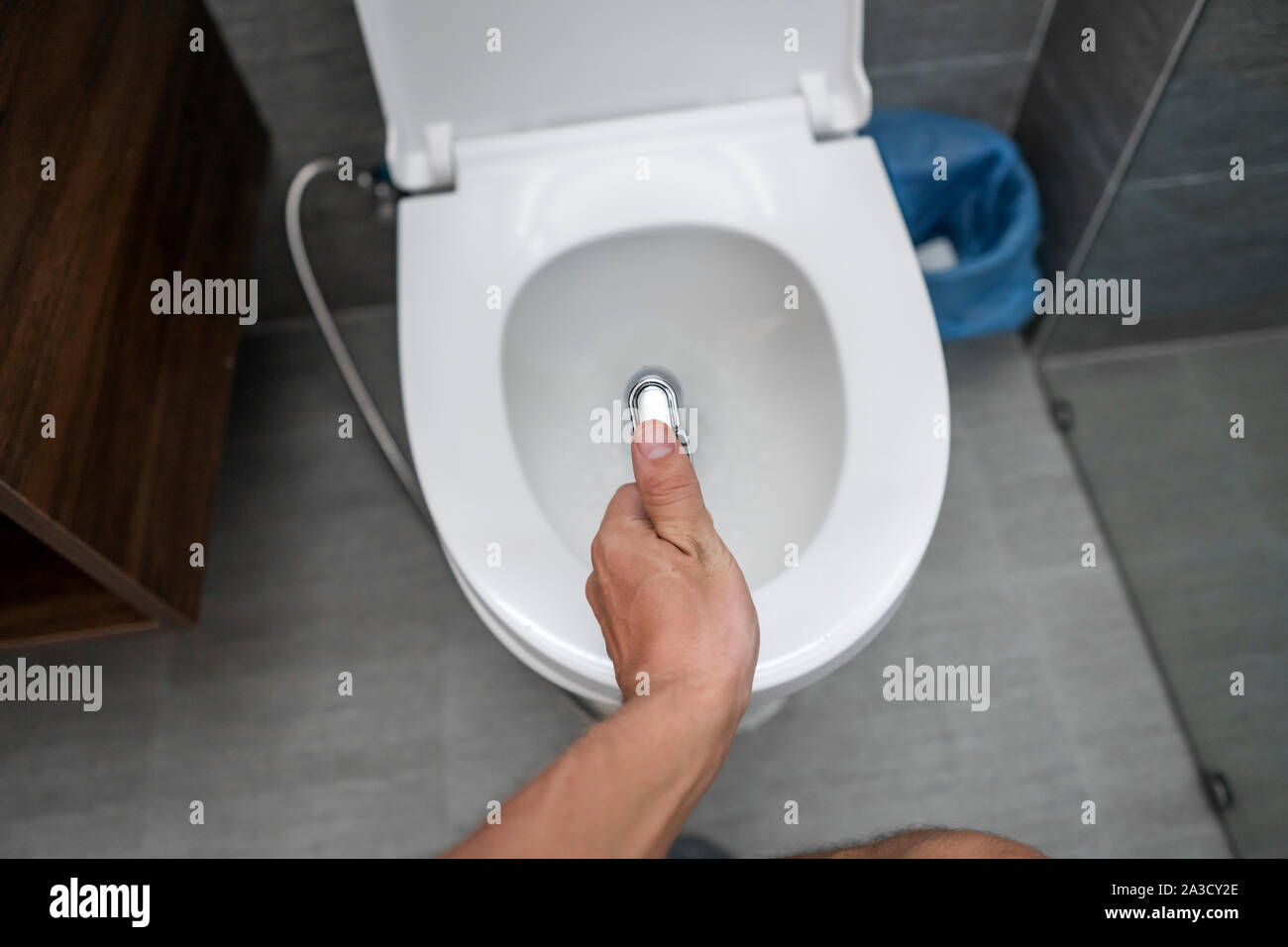 Ducha higiénica en la mano con un chorro de agua, de cerca en un inodoro  blanco Fotografía de stock - Alamy