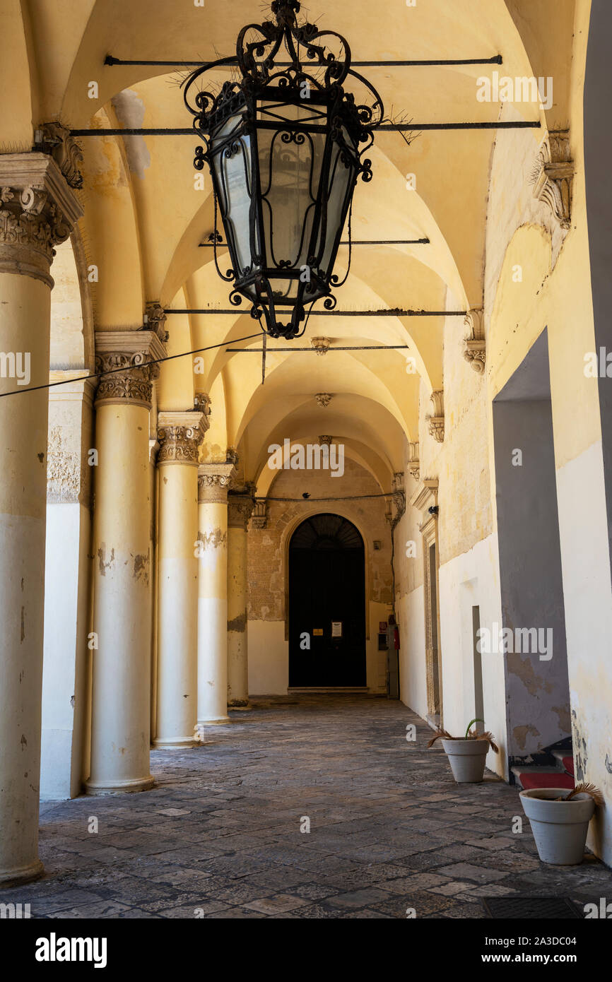 Colonnade arqueada en el patio del Palacio del Governo (Palacio de Gobierno) en el antiguo convento de Celestina en Lecce, Apulia (Puglia), Sur de Italia Foto de stock