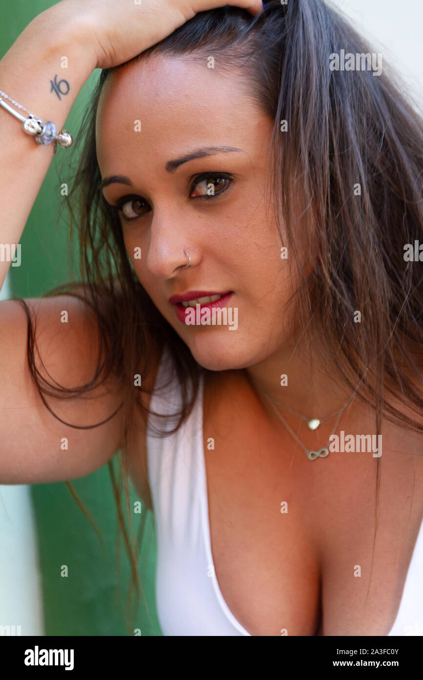 Mujer joven con ojos de gato, sin miedo, mientras jugaba con su cabello Foto de stock