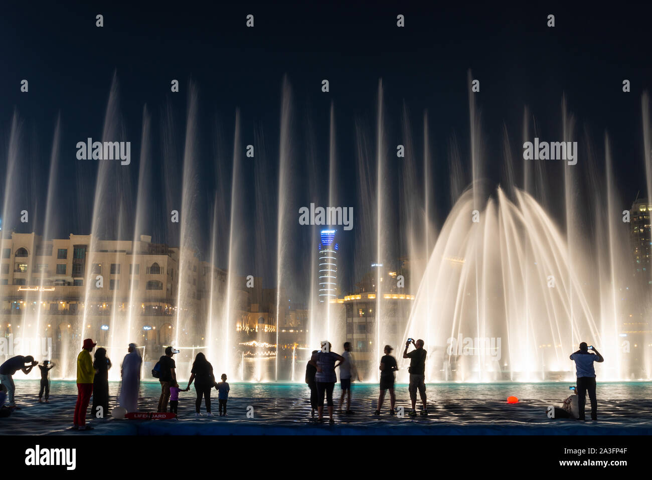 Siluetas de gente disfrutando de la fuente en la noche Show en Dubai, Emiratos Árabes Unidos Foto de stock