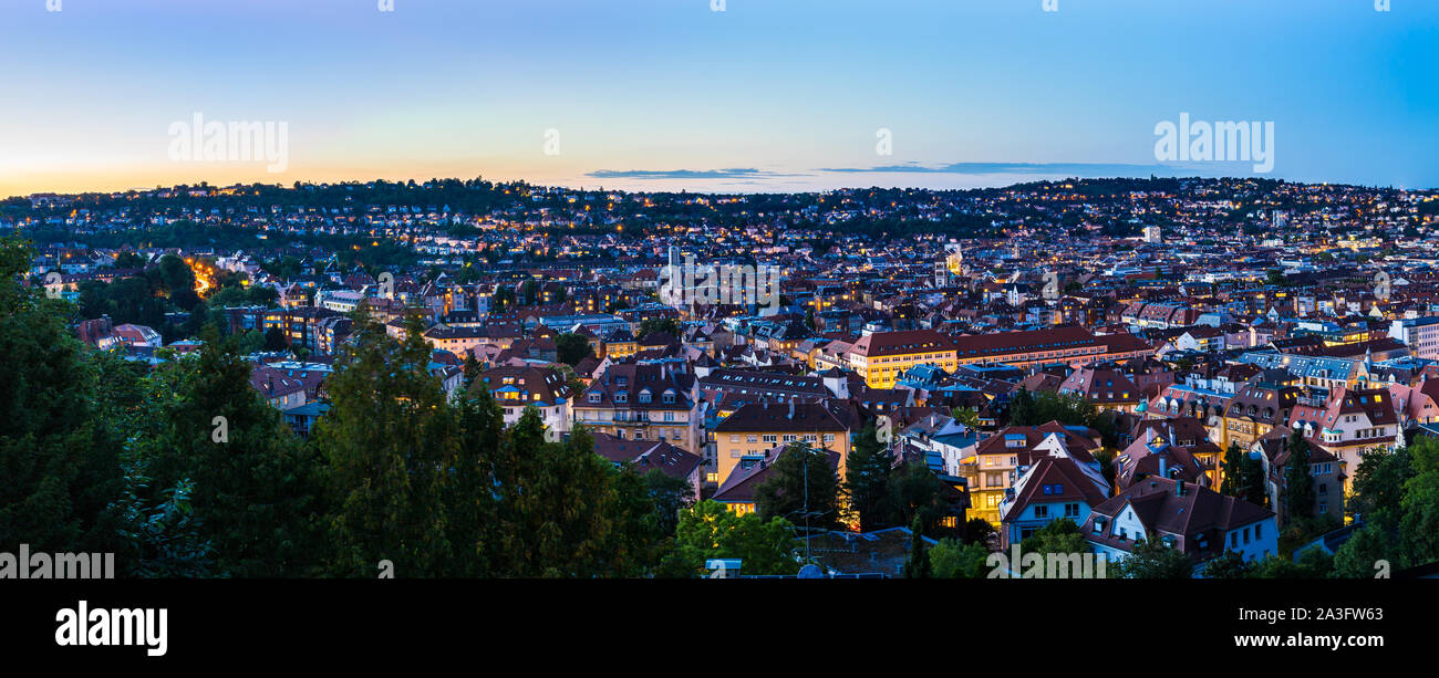 Alemania, XXL panorama de Atardecer cielo sobre el paisaje urbano de la ciudad de Stuttgart Casas y azoteas, vista aérea desde arriba sobre el horizonte iluminado en verano Foto de stock