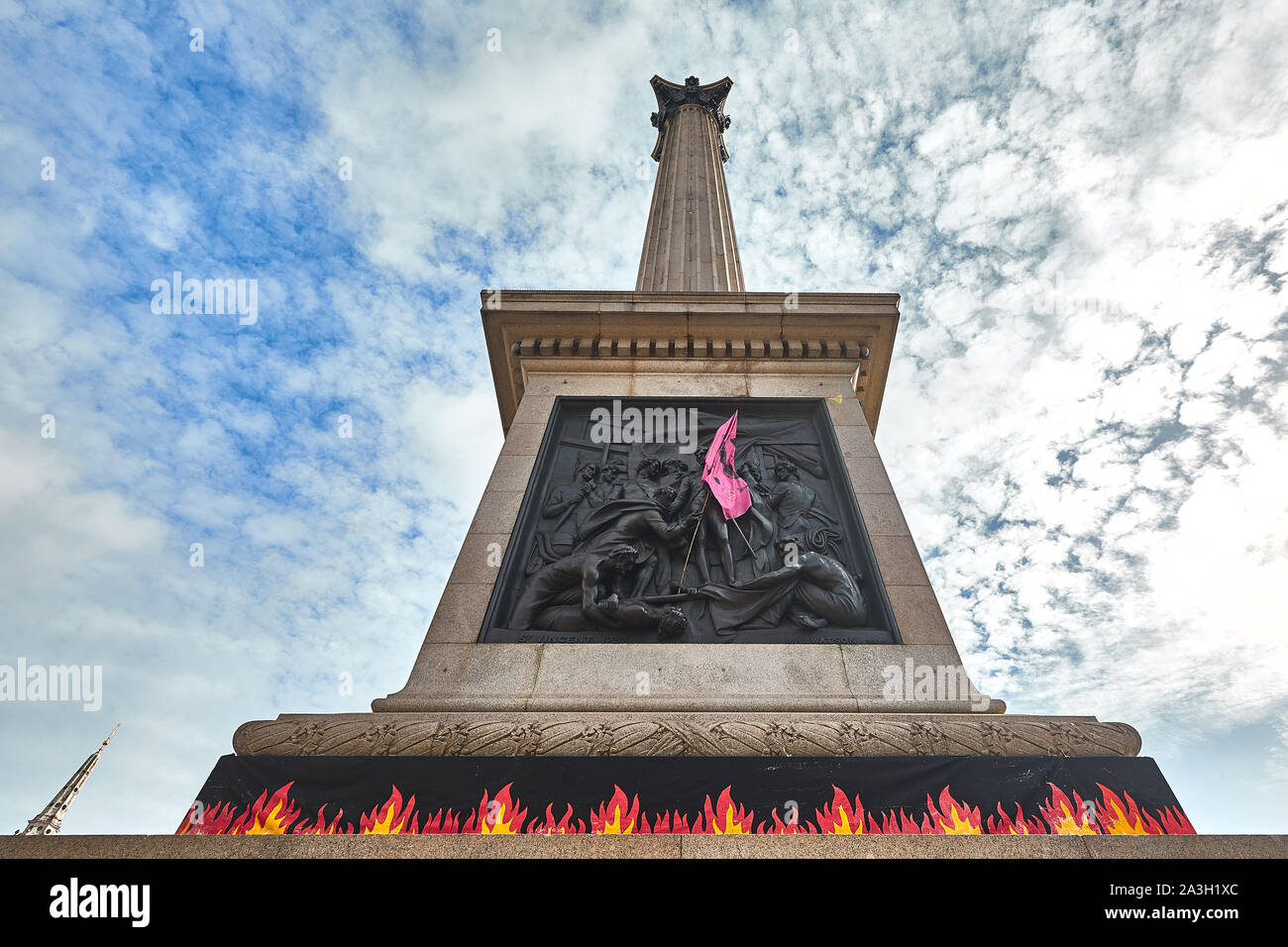Londres, Reino Unido - Oct 8, 2019: Las llamas colocados alrededor de la base de la columna de Nelson por activistas de extinción Rebelión en el segundo día de una ocupación de Trafalgar Square. Foto de stock