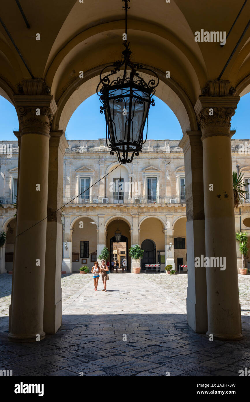 Vista a través del arco en el patio del Palacio del Governo (Palacio de Gobierno) en el antiguo convento de Celestina en Lecce, Apulia (Puglia), Sur de Italia Foto de stock