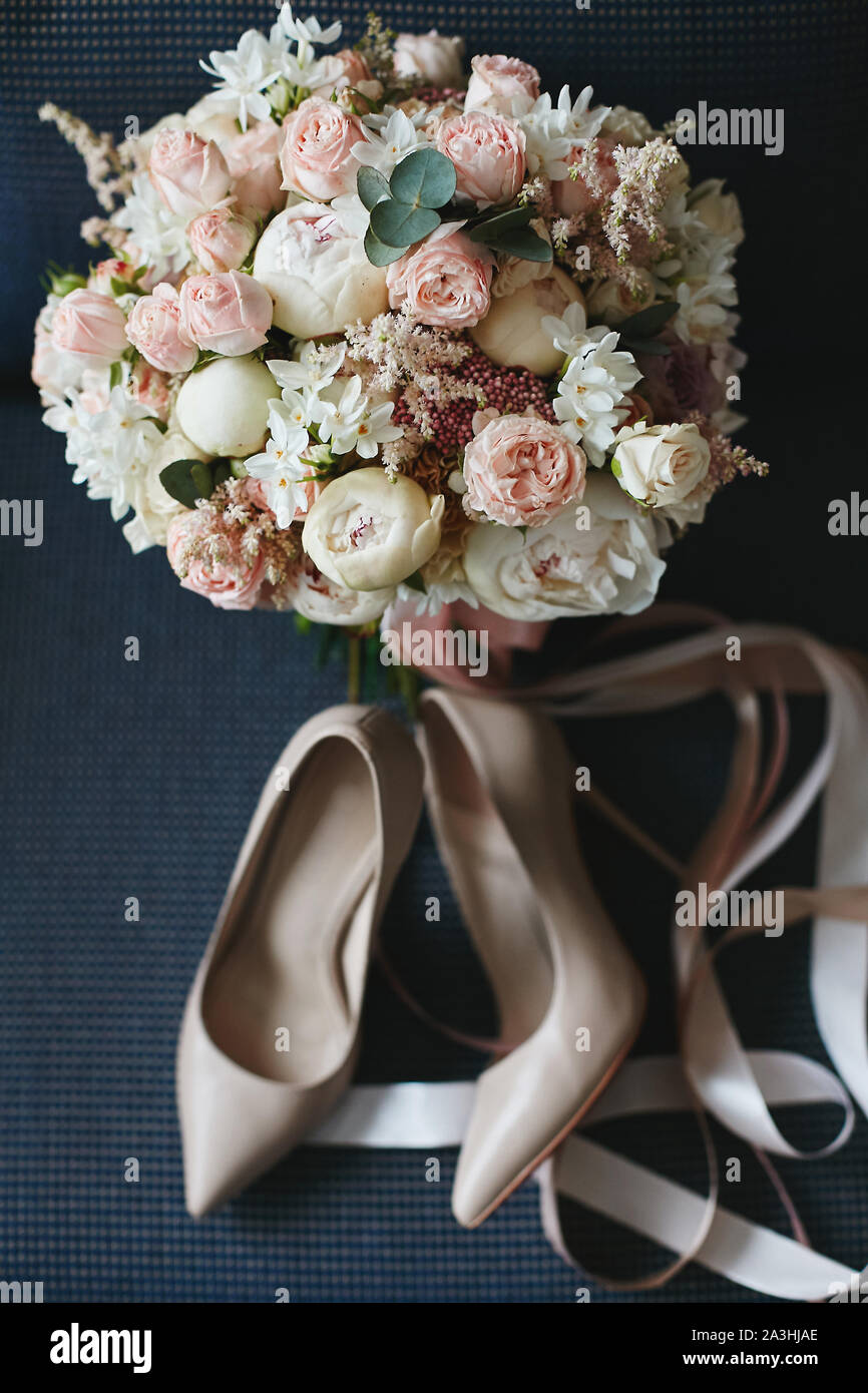 Composición del ramo de novia de hermosas peonías flores con un par de  zapatos de novia modish sobre un fondo azul oscuro. Concepto de boda  Fotografía de stock - Alamy