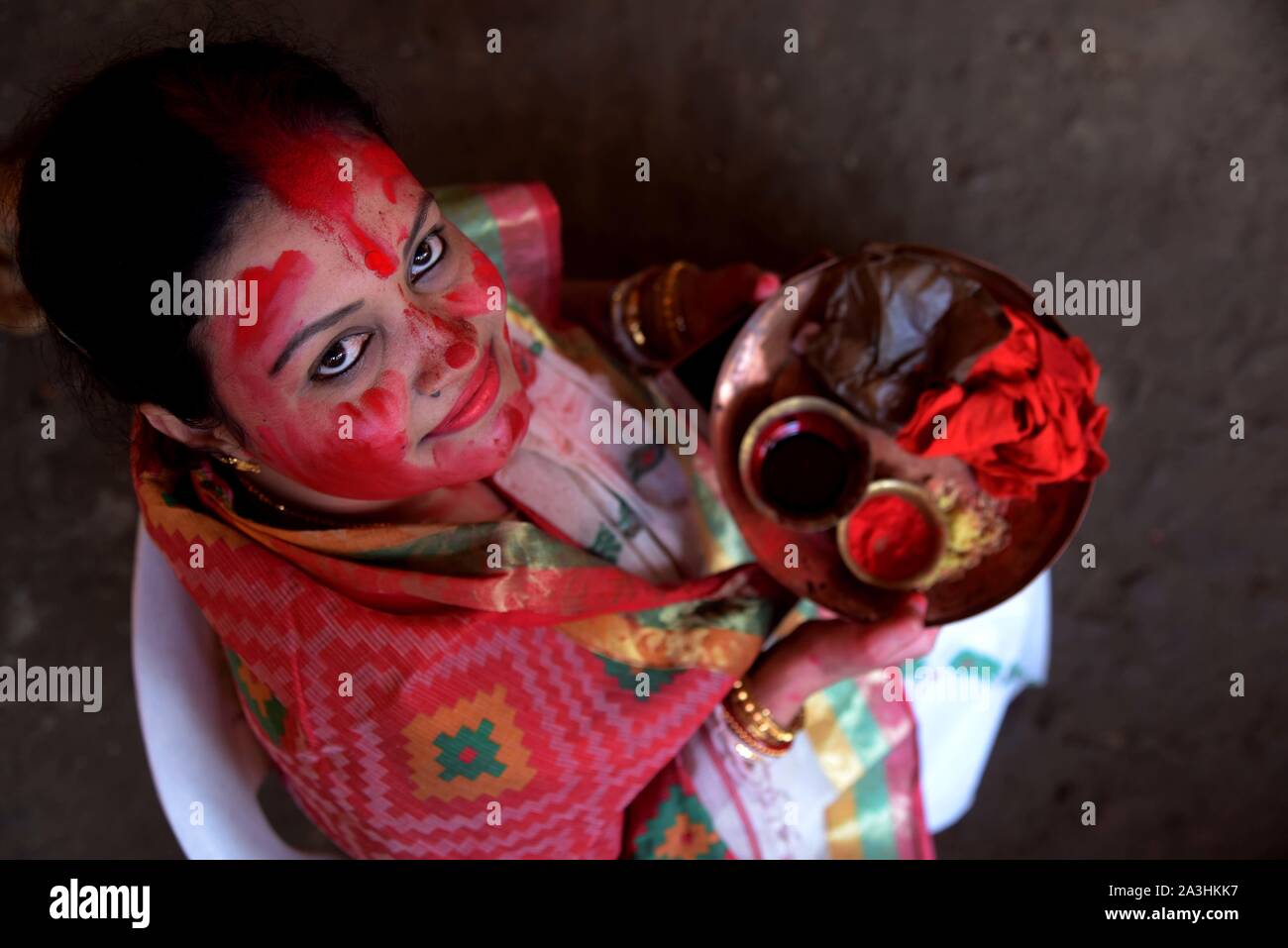 Allahabad, Uttar Pradesh, India. 8 Oct, 2019. Una mujer como ella la cámara reacciona a descansar después de tomar parte en ''Sindhur Khela'' procesión antes de sumergir el ídolo de la diosa Durga en un estanque con ocasión del Festival VijayDashmi en Allahabad(Prayagraj) el martes, 08 de octubre de 2019. Crédito: Prabhat Kumar Verma/Zuma alambre/Alamy Live News Foto de stock