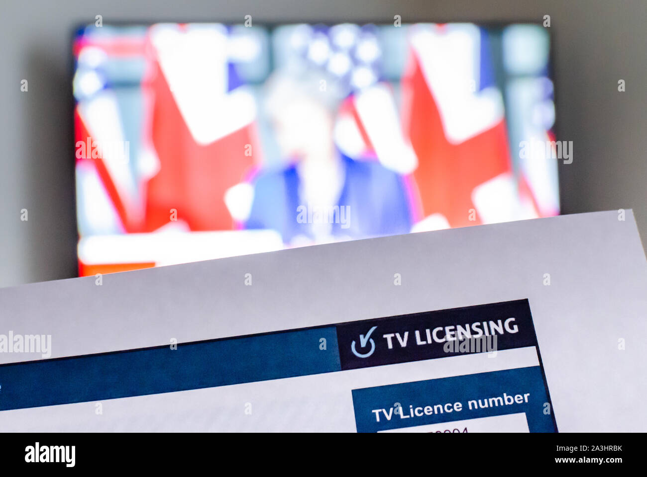 Licencia de TV británica y pantalla de TV con el canal de noticias en el fondo. Publicado por 'TV' de licencias en nombre de la BBC Foto de stock