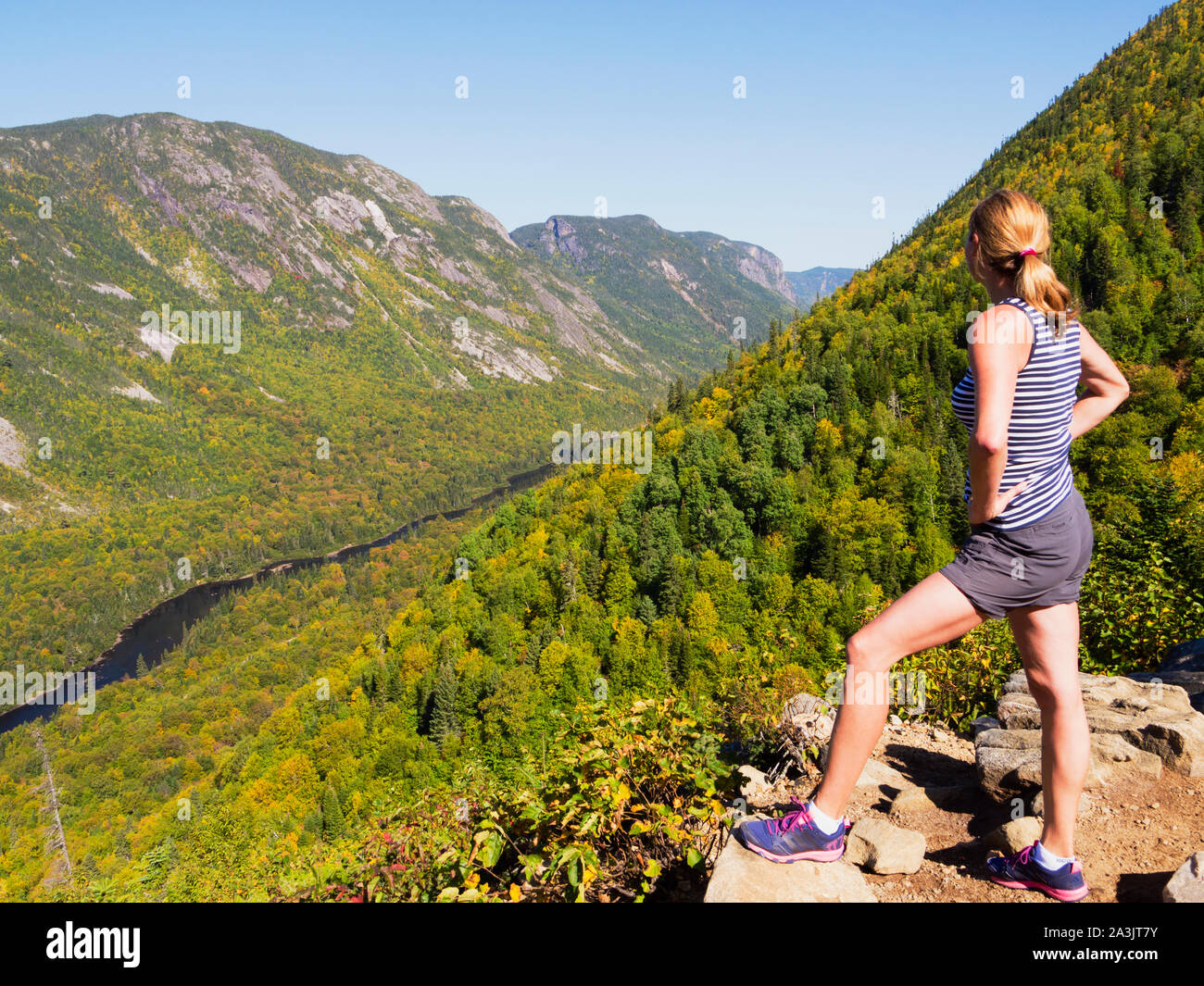 Mujer de pie con vista al Hautes-Gorges-de-la-Rivière-Malbaie Provincial Park, Quebec, Canadá Foto de stock