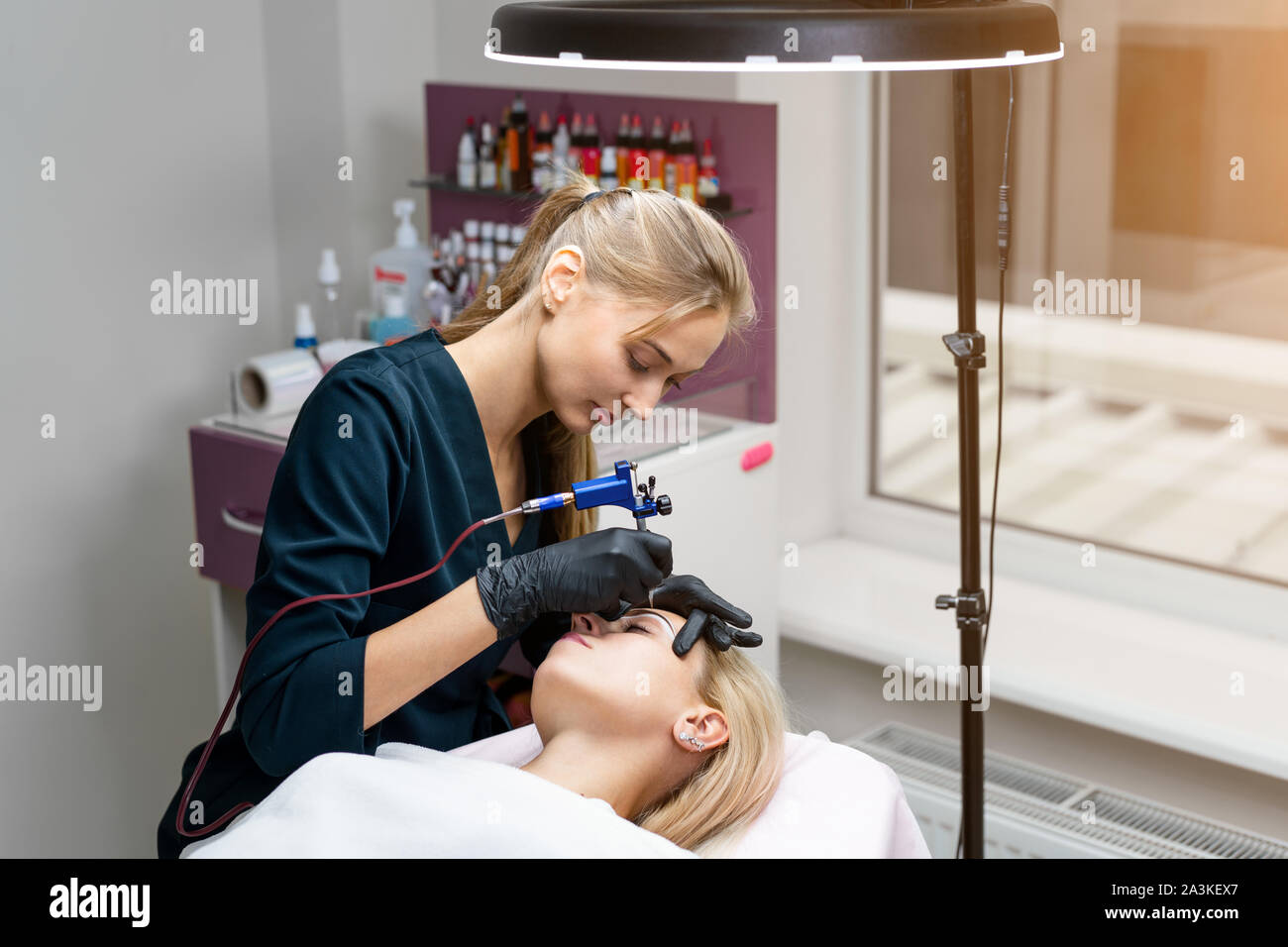 Gabinete de cosmetología client yace sobre un sofá. Esteticista aplica  tinta permanente en las cejas. Procedimiento de maquillaje permanente de  cejas. Espacio libre. Belleza indu Fotografía de stock - Alamy