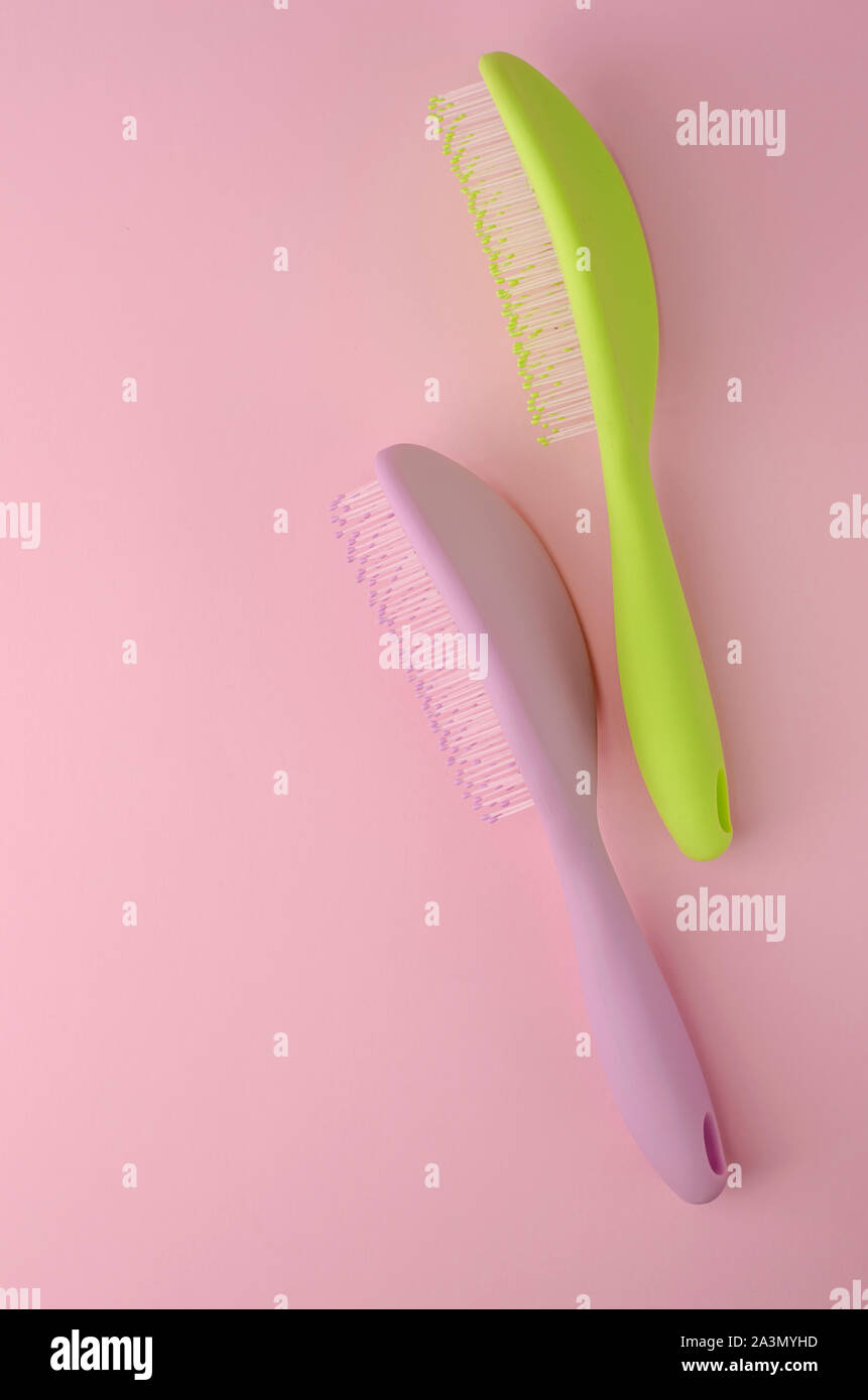 Los productos de cuidado del cabello. Colorido peinetas para masaje del cuero  cabelludo sobre fondo de color rosa. Lay, planas verticales con espacio de  copia Fotografía de stock - Alamy