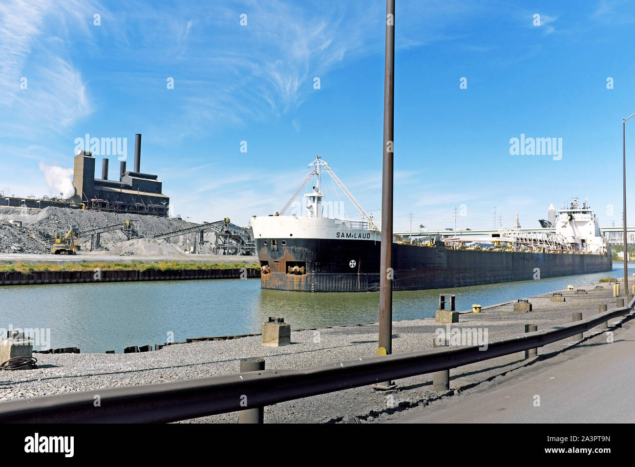 El carguero baja por el río Cuyahoga pasando un molino de acero en Cleveland, Ohio, Estados Unidos. Foto de stock