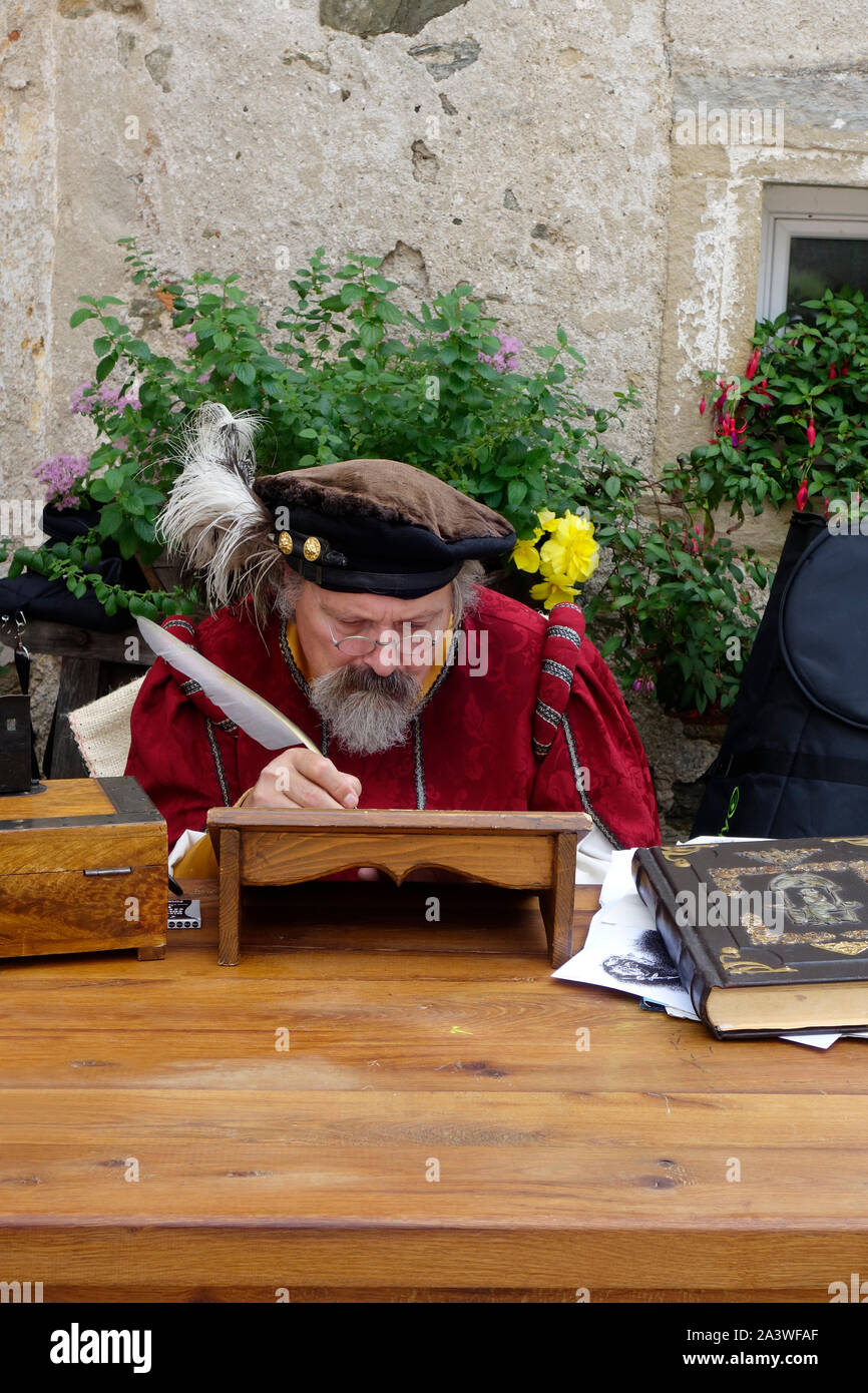Un hombre con edredones de pluma de oca Dip hueco vintage actúa un renacimiento scribe durante jornadas medievales en Tabor mansión en Visnja vas (aldea), Dvojnik. Eslovenia. Foto de stock
