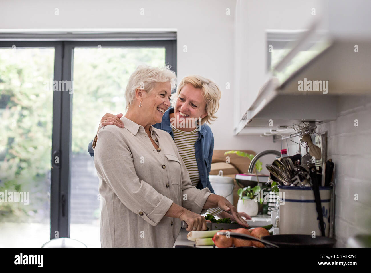 Pareja de lesbianas maduras cocinar una comida juntos en casa Foto de stock