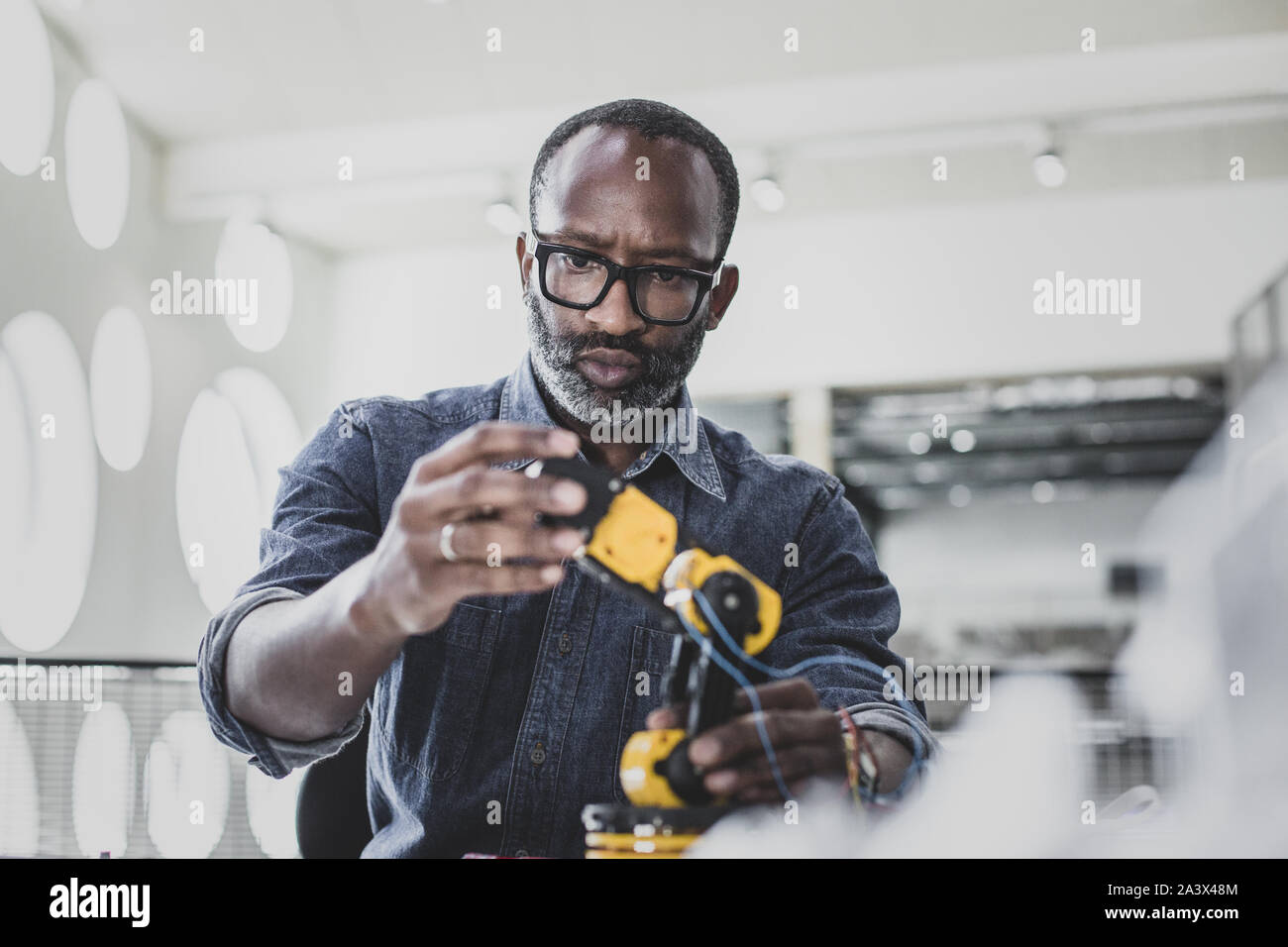 Closeup ofAfrican American macho adulto trabajando en robótica Foto de stock
