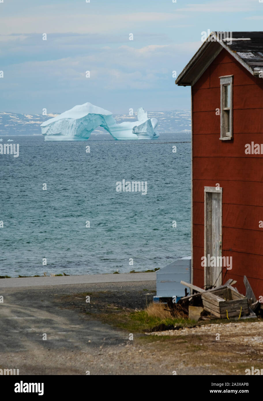 Iceberg en Green Island Cove con granero rojo en primer plano, Terranova Foto de stock