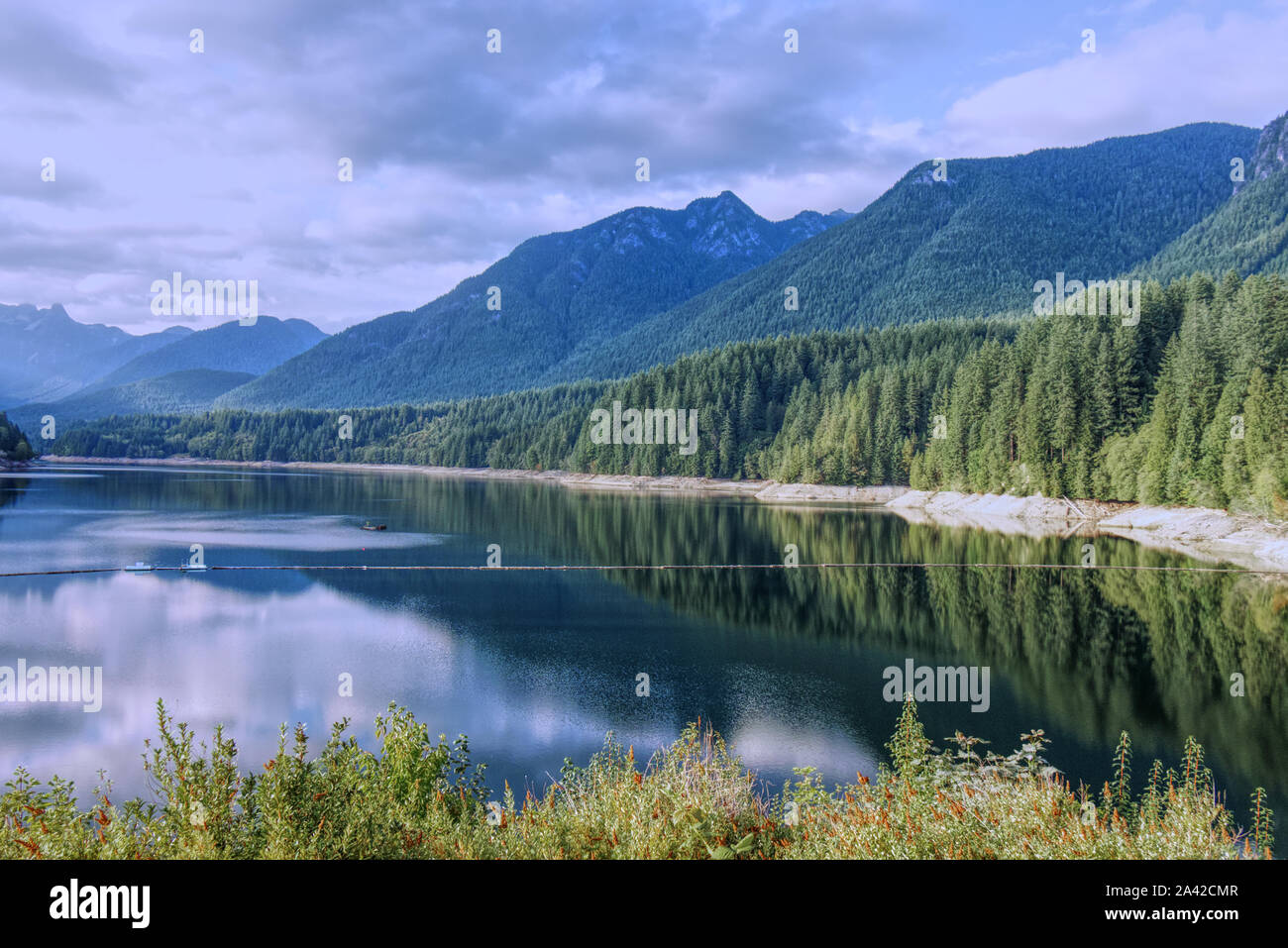 Una vista escénica de Cleveland embalse rodeado de montañas al atardecer, North Vancouver, Canadá Foto de stock