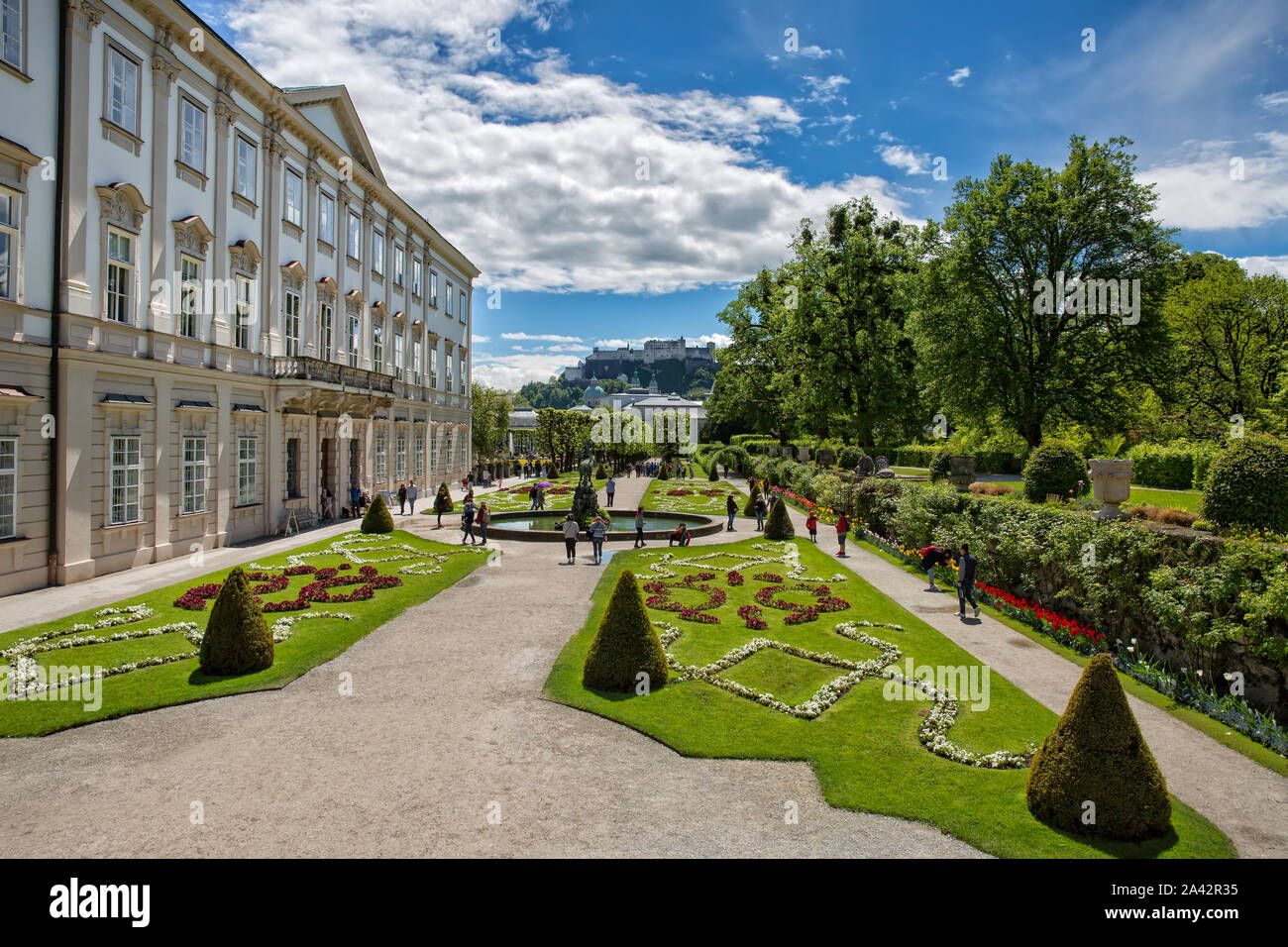 Salzburgo, Austria - 12 de mayo de 2017:Schloßpark Mirabell con turistas. Vista maravillosa sobre Schloßpark Mirabell con fortaleza de Hohensalzburg en el fondo Foto de stock