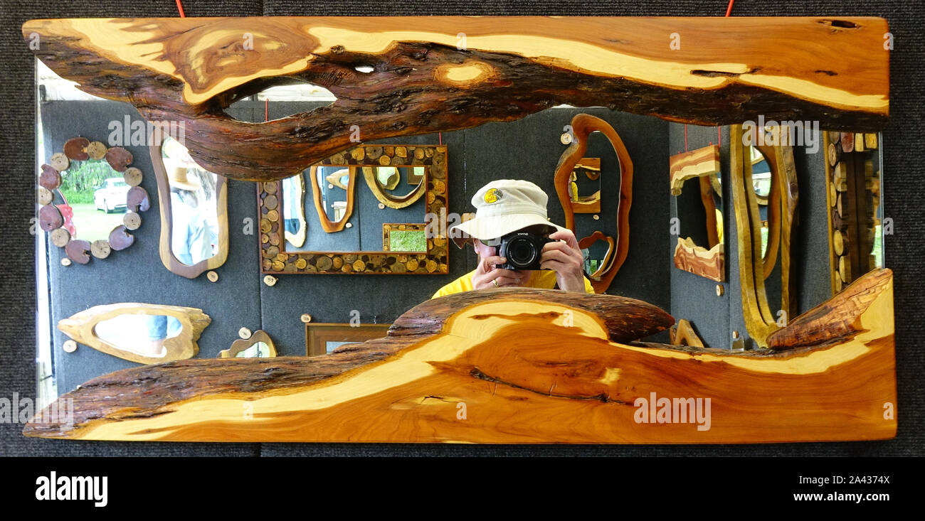 Reflejo en un espejo decorativo en un stand en una demostración del arte mostrando el fotógrafo Foto de stock