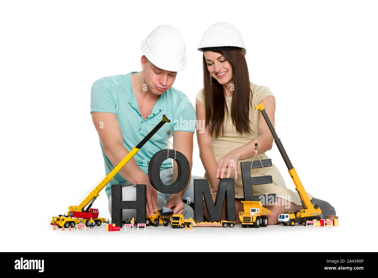 Casa en construcción: alegre pareja con máquinas de construcción de  casa-palabra Fotografía de stock - Alamy