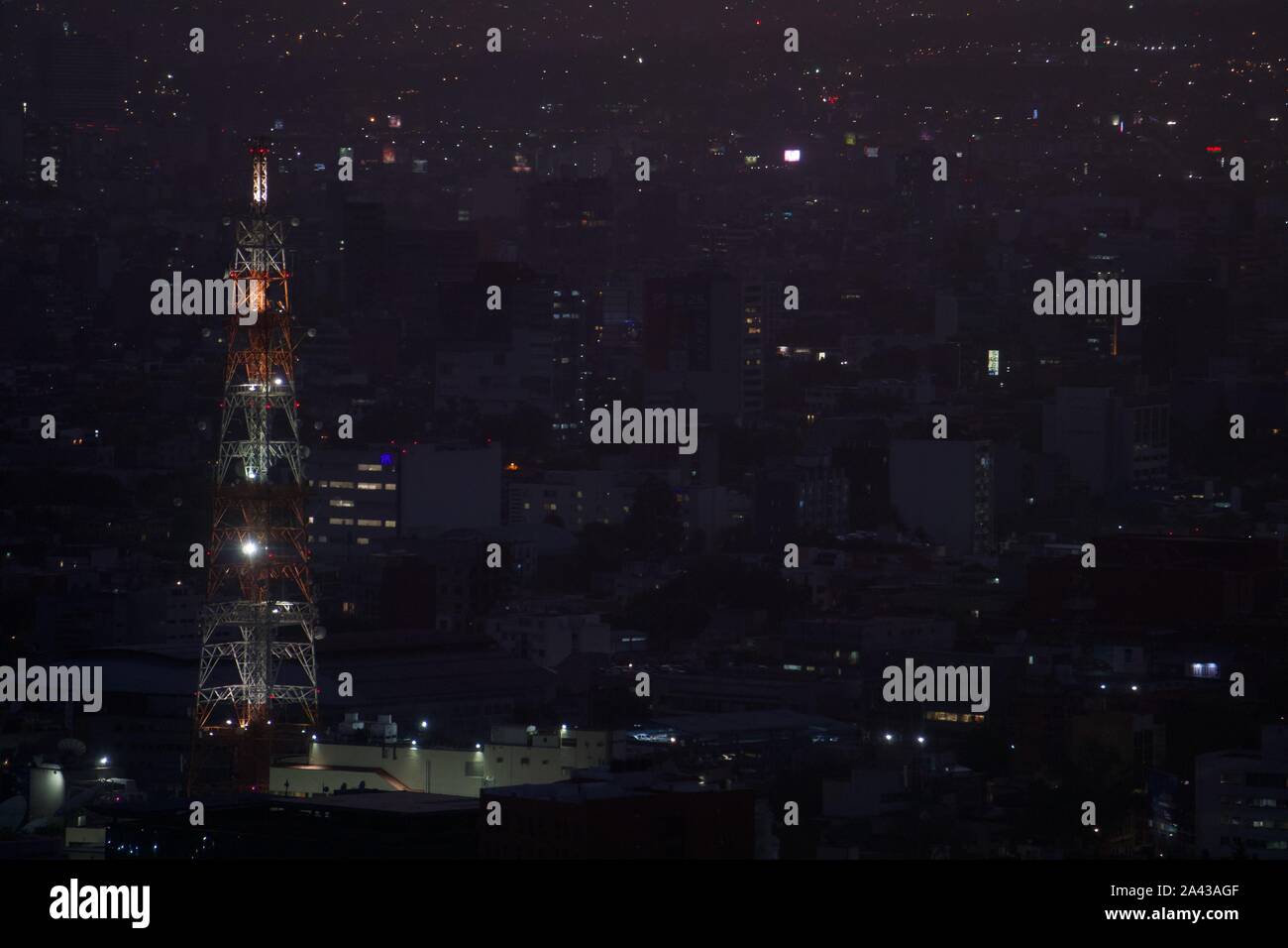 Vintage rojo y blanco de la torre de la radio en la noche, respaldada por  las luces de la ciudad y de la densidad urbana. Ciudad de México, México  Fotografía de stock -