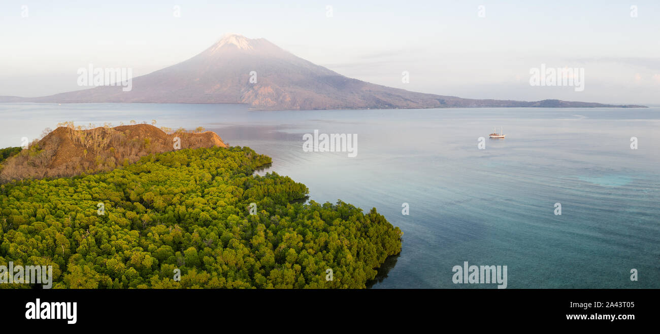 Amanecer ilumina el volcán Iliape encontró justo al este de Flores, en Indonesia. Esta zona tropical es parte del famoso anillo de fuego. Foto de stock