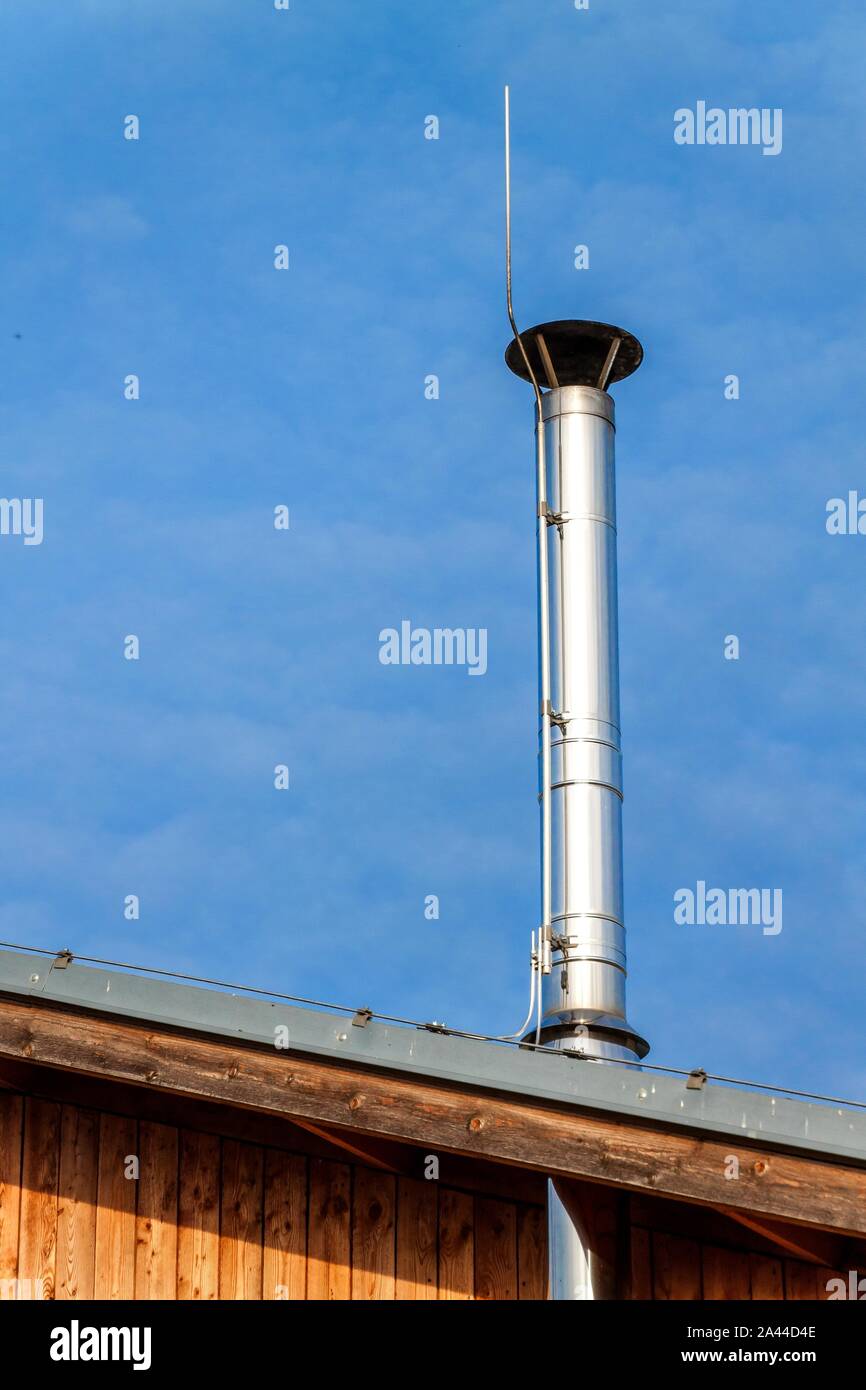 Nuevo tubo de chimenea de metal en casa de madera. Acero inoxidable chimenea  en casa. Calefacción de leña ecológica. Medio ambiente. Pararrayos en la  chimenea Fotografía de stock - Alamy