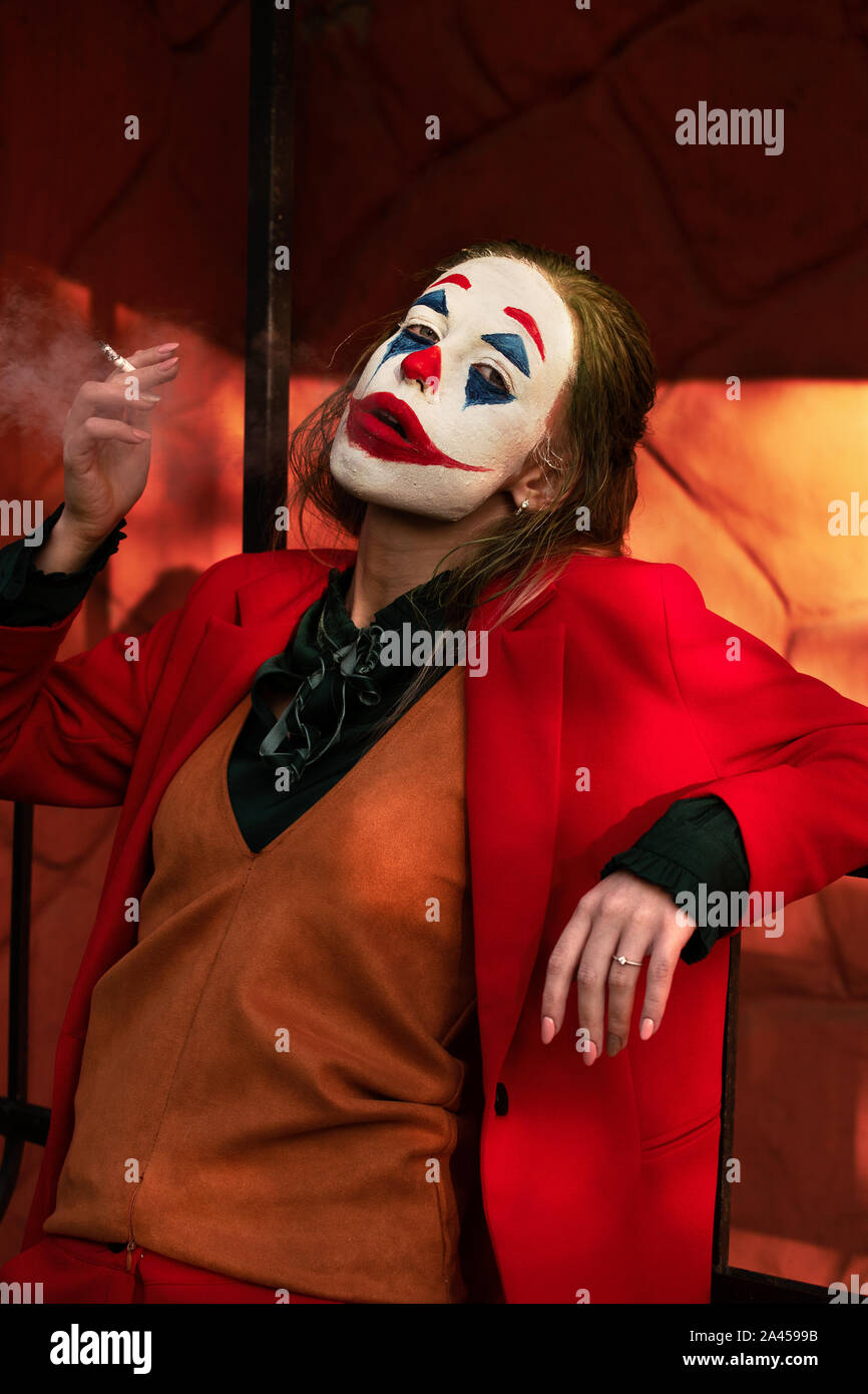 Mujer joven con Joker maquillaje y el vestuario de fumar Fotografía de  stock - Alamy