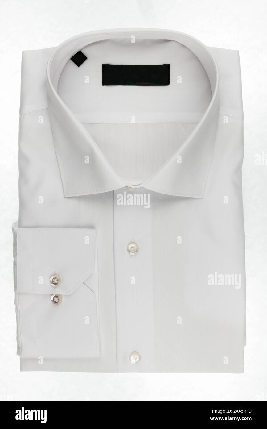 Plegado clásico blanco camisa de hombre aislado sobre un fondo blanco. La moda y los negocios Foto de stock
