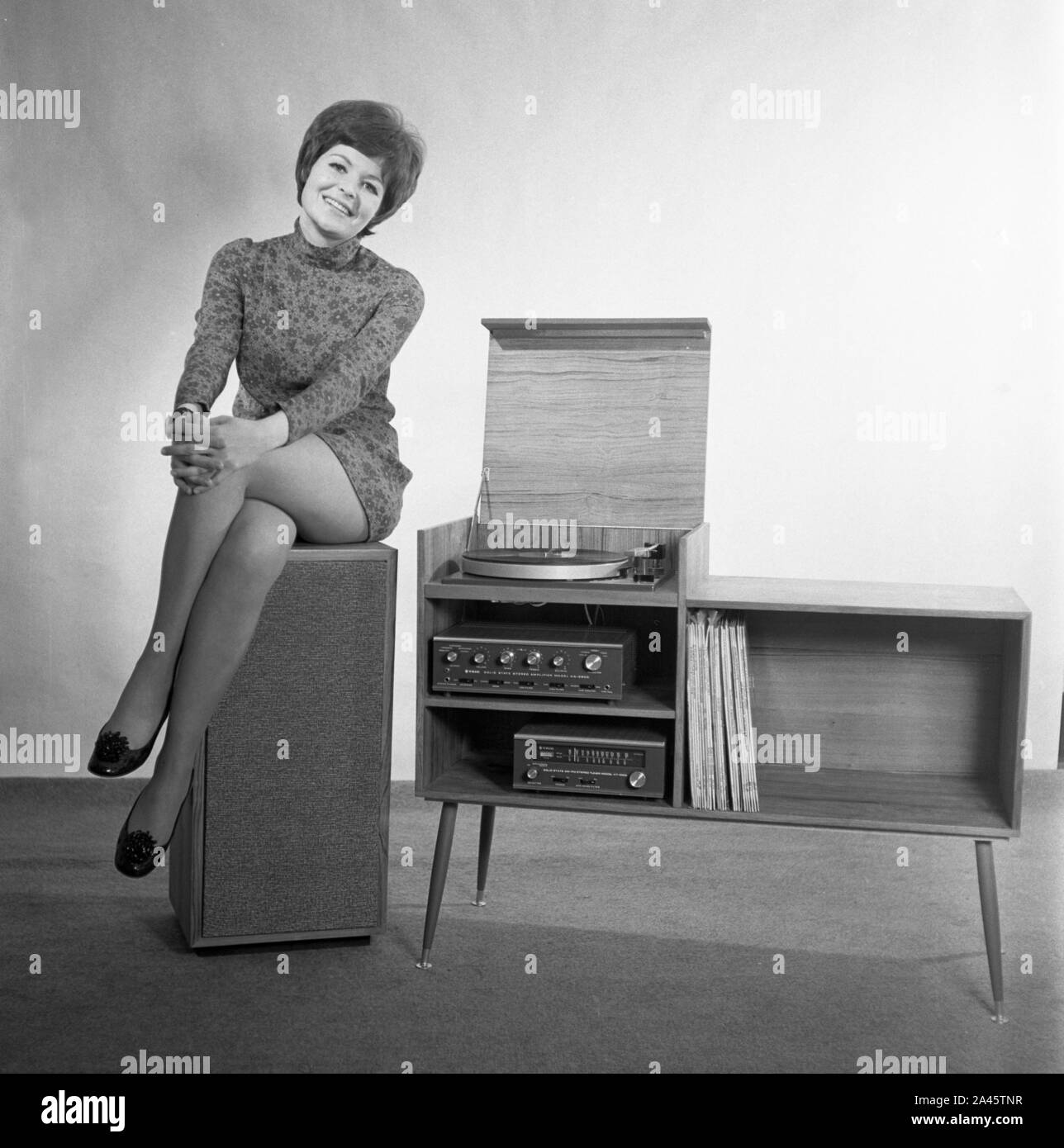 Modelo con pelo corto plantea, en un mini-vestido con un sistema de sonido estéreo c1969 Foto por Tony Henshaw Archive Foto de stock