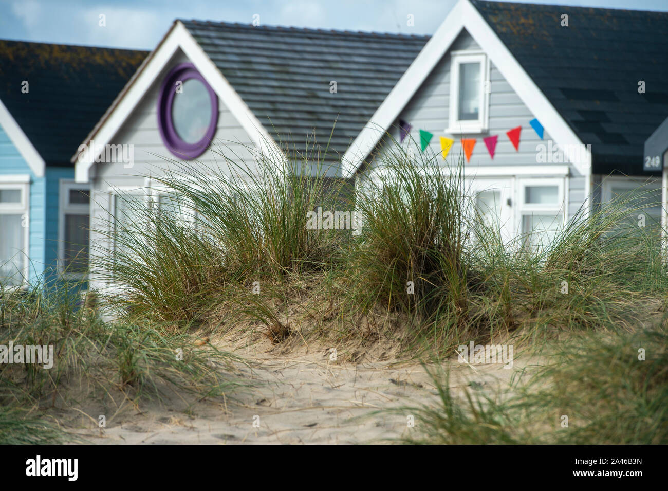 Holiday Beach cabañas a lo largo del pintoresco Mudeford escupen Hengistbury head en Dorset. Las cabañas de playa son considerados como los más caros cabañas de playa en el país, a pesar de no tener agua potable, instalaciones sanitarias y de electricidad. Foto de stock