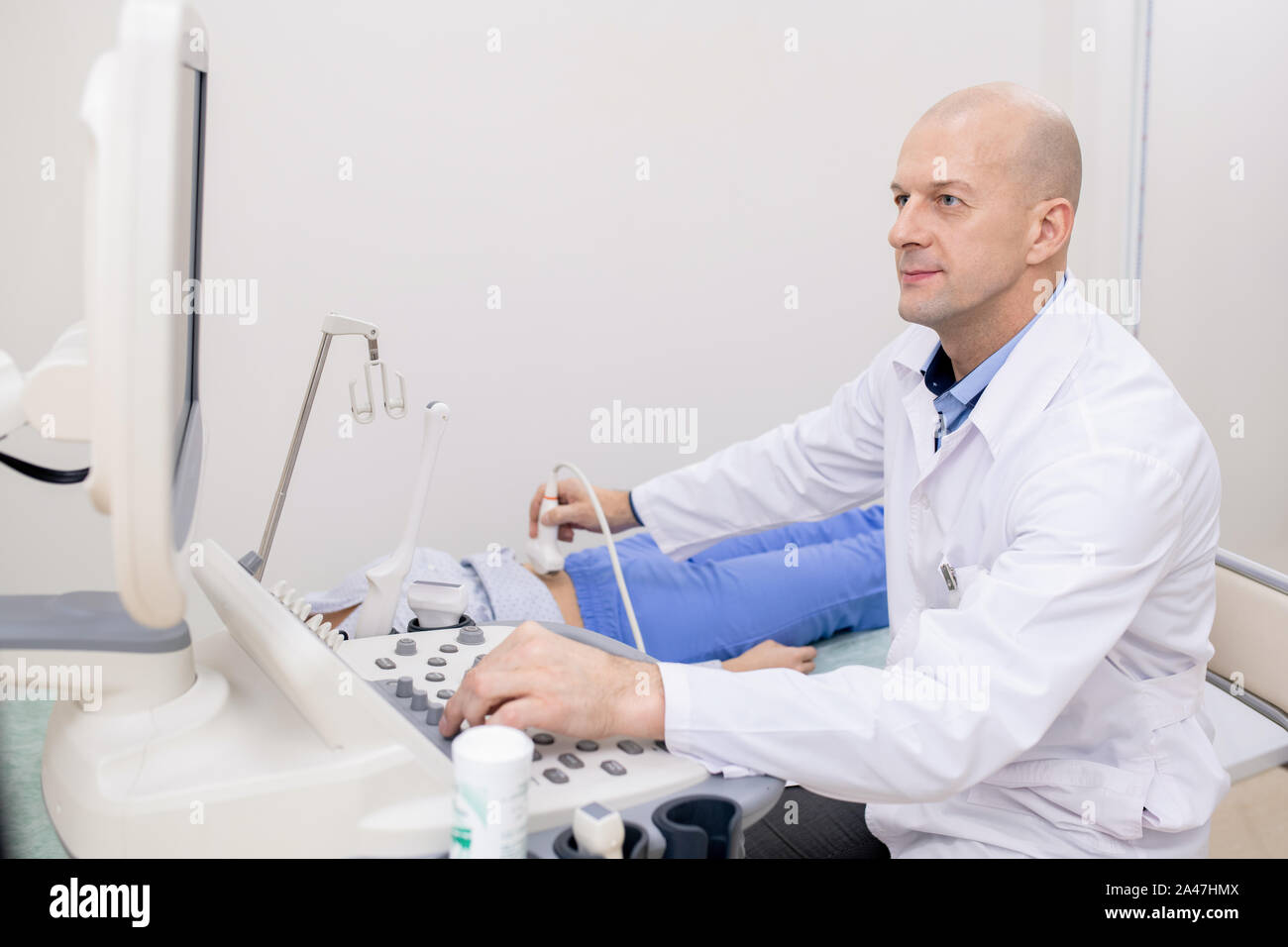 Seguro profesional en pantalla mientras realiza el examen ultrasónico Foto de stock