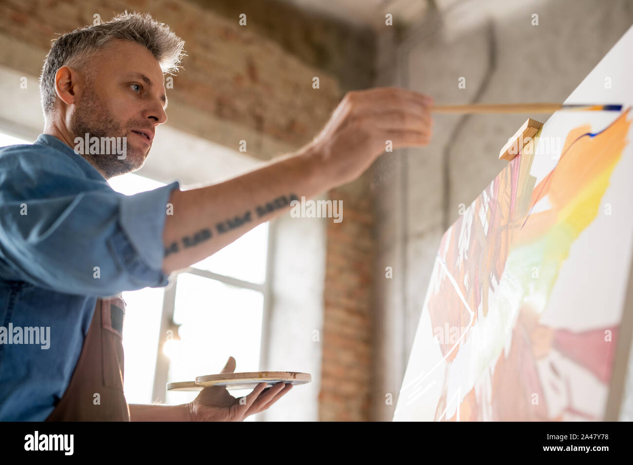 Artista serio para concentrarse en la nueva obra maestra de pintura de caballete Foto de stock