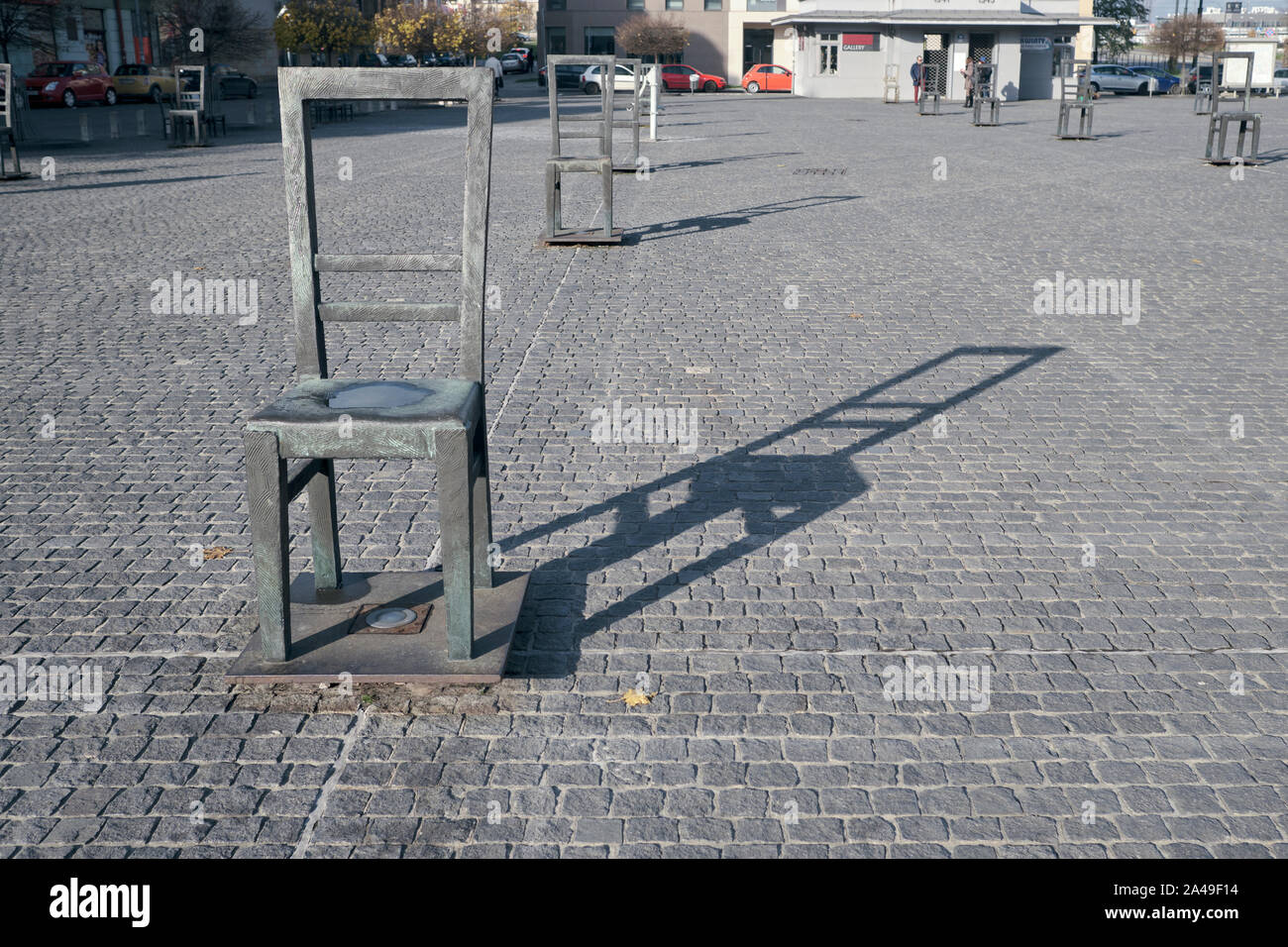 Silla vacía y su sombra en la Plaza de los héroes del Ghetto Memorial en Cracovia, Polonia. Foto de stock