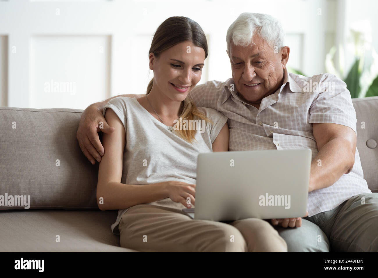 Abuelo y nieta de adultos pasan tiempo juntos usar el laptop Foto de stock