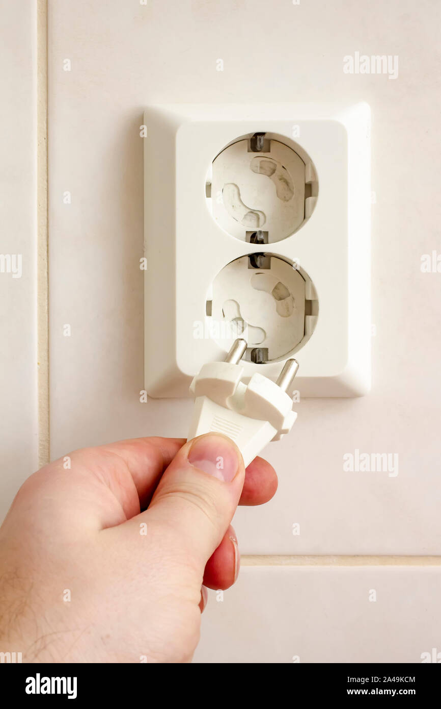 Primer plano de la mano de insertar un enchufe eléctrico en una toma de  pared Fotografía de stock - Alamy