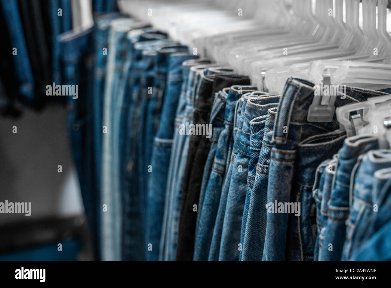 Pantalones jeans de moda y en el rack en tienda de ropa. Venta, compras,  moda, estilo concepto. Jean pantalones cuelgan en la estantería . Close Up  shot Vintage Denim Fotografía de stock -