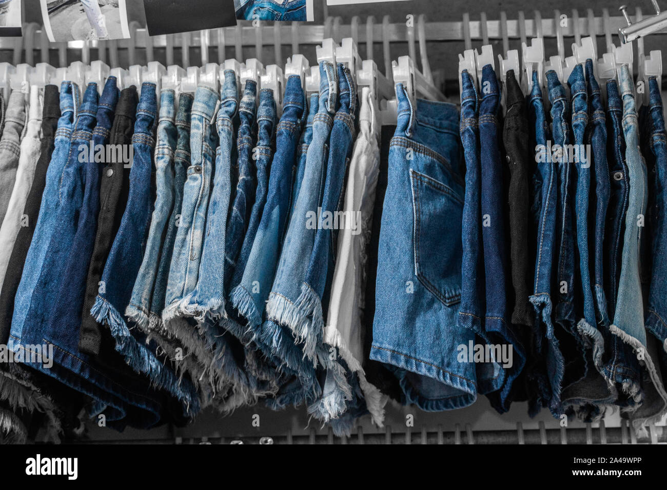 Pantalones jeans de moda y en el rack en tienda de ropa. compras, moda, estilo concepto. Jean cuelgan la estantería . Close Up shot Vintage Denim Fotografía de stock -
