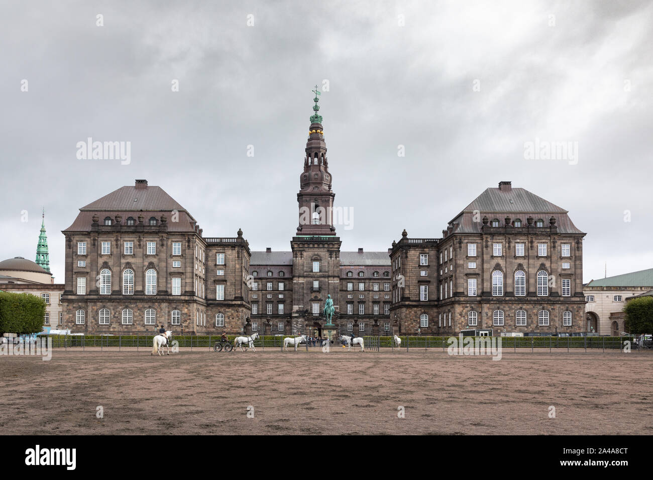 Copenhague, Dinamarca: caballos blancos ejercicio delante de Christiansborg Palace que está situado en el islote de Slotsholmen en la ciudad capital. Foto de stock